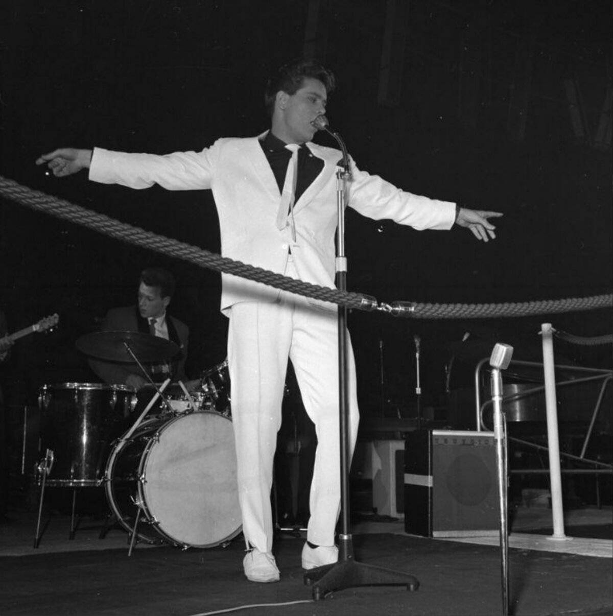 Singer Performing on Stage in White Suit