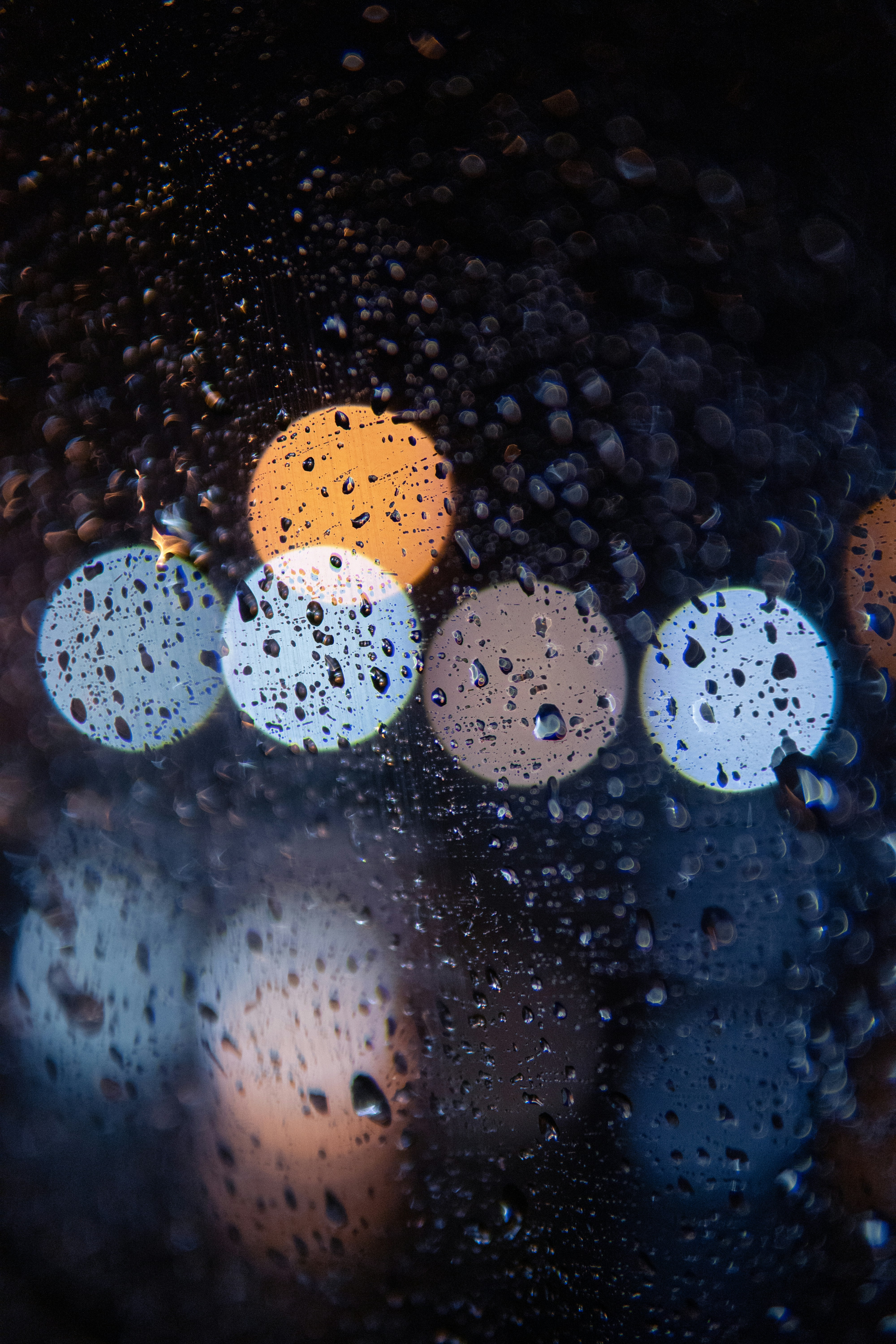 Raindrops on Glass With Blurred Lights
