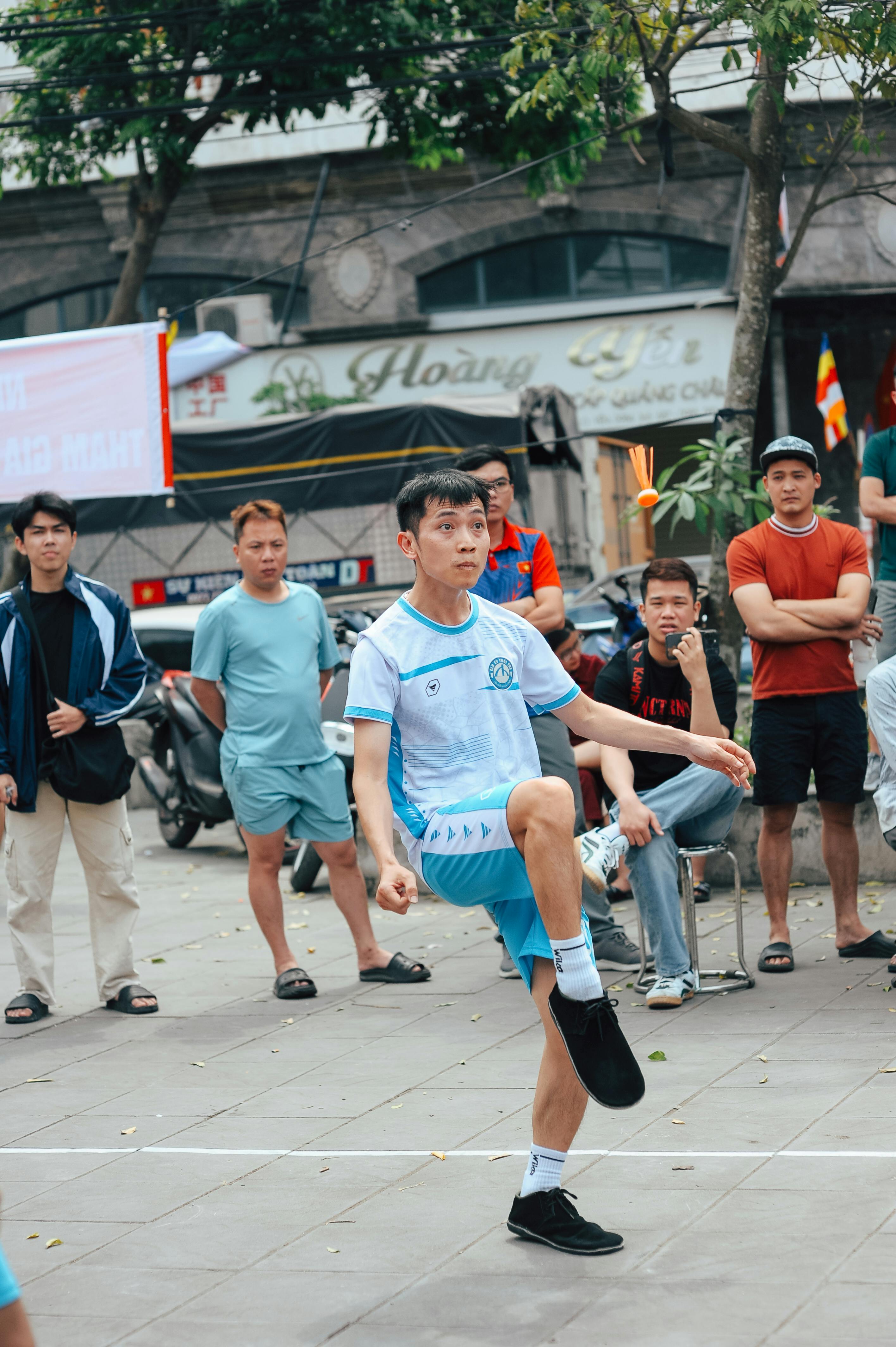 Man Playing Shuttlecock Kicking on Street