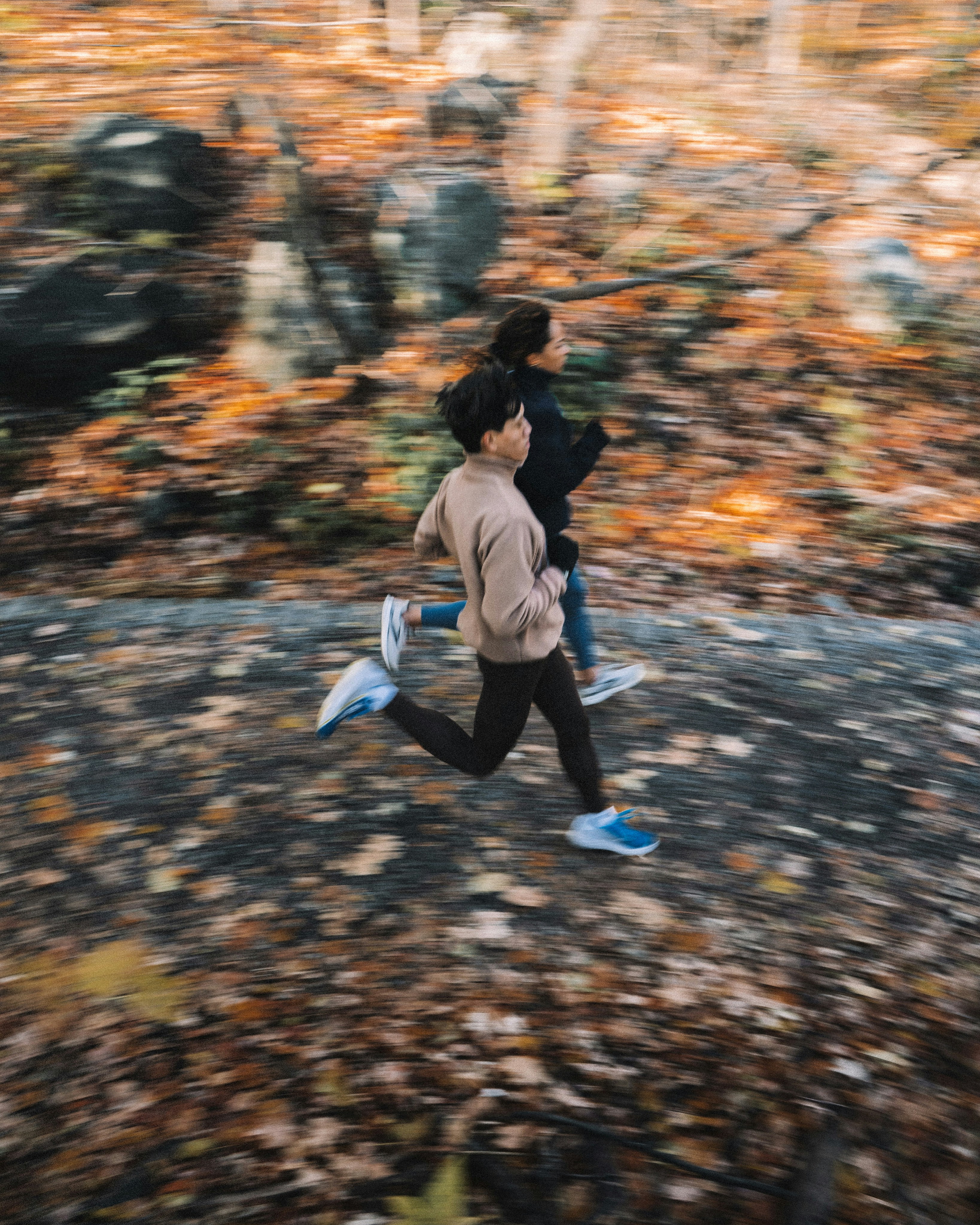Two People Trail Running in Autumn Woods