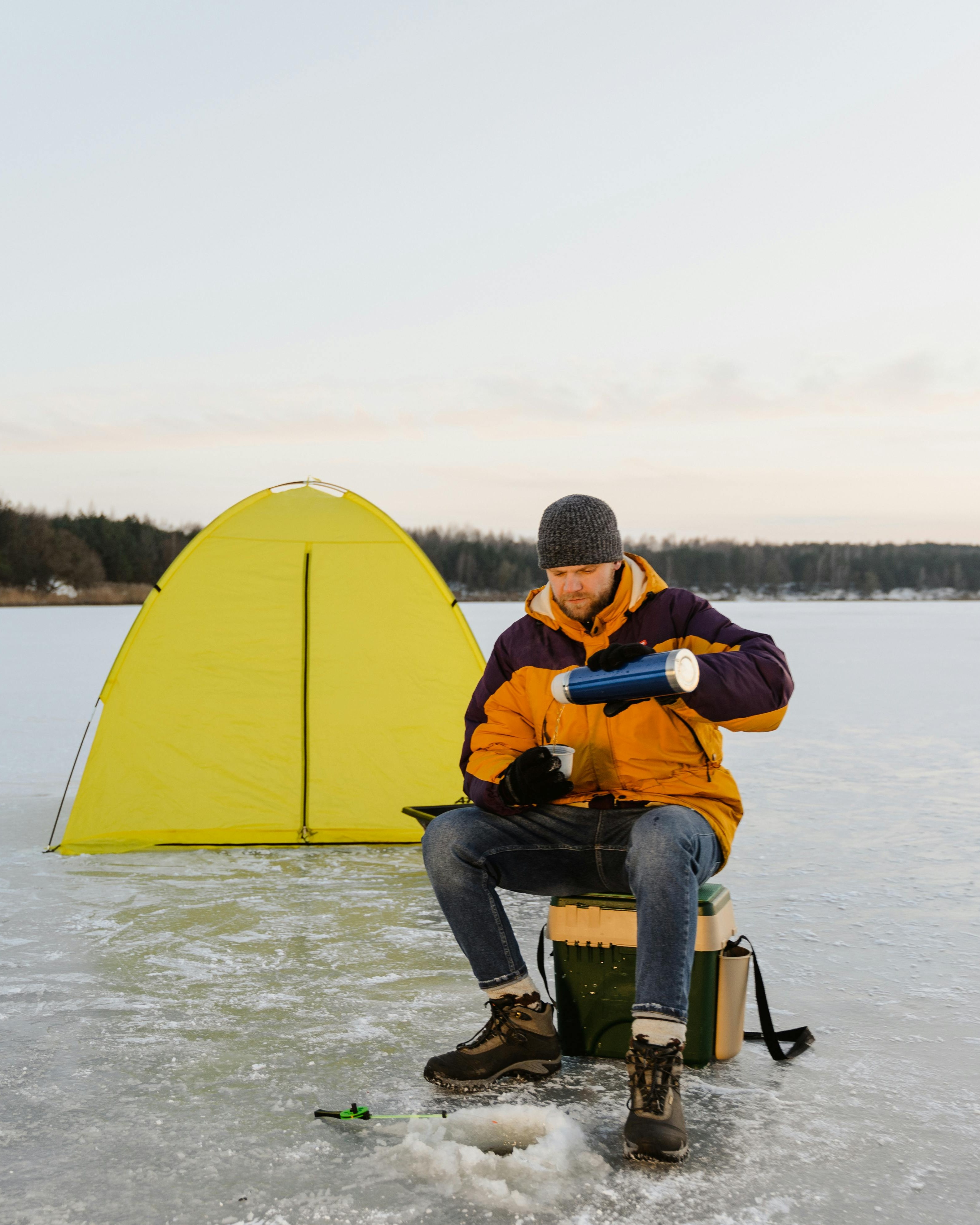 Man Ice Fishing on Frozen Lake