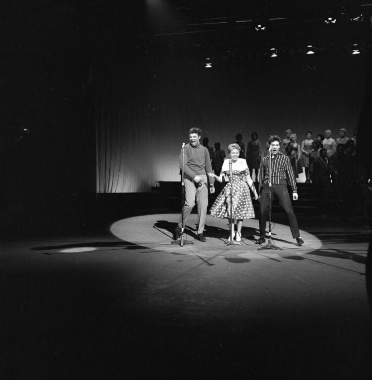 Three Singers Performing On Stage