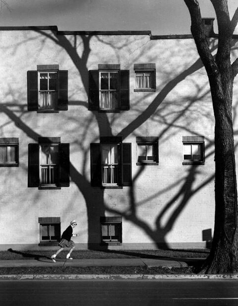 Girl Running By Building With Tree Shadow