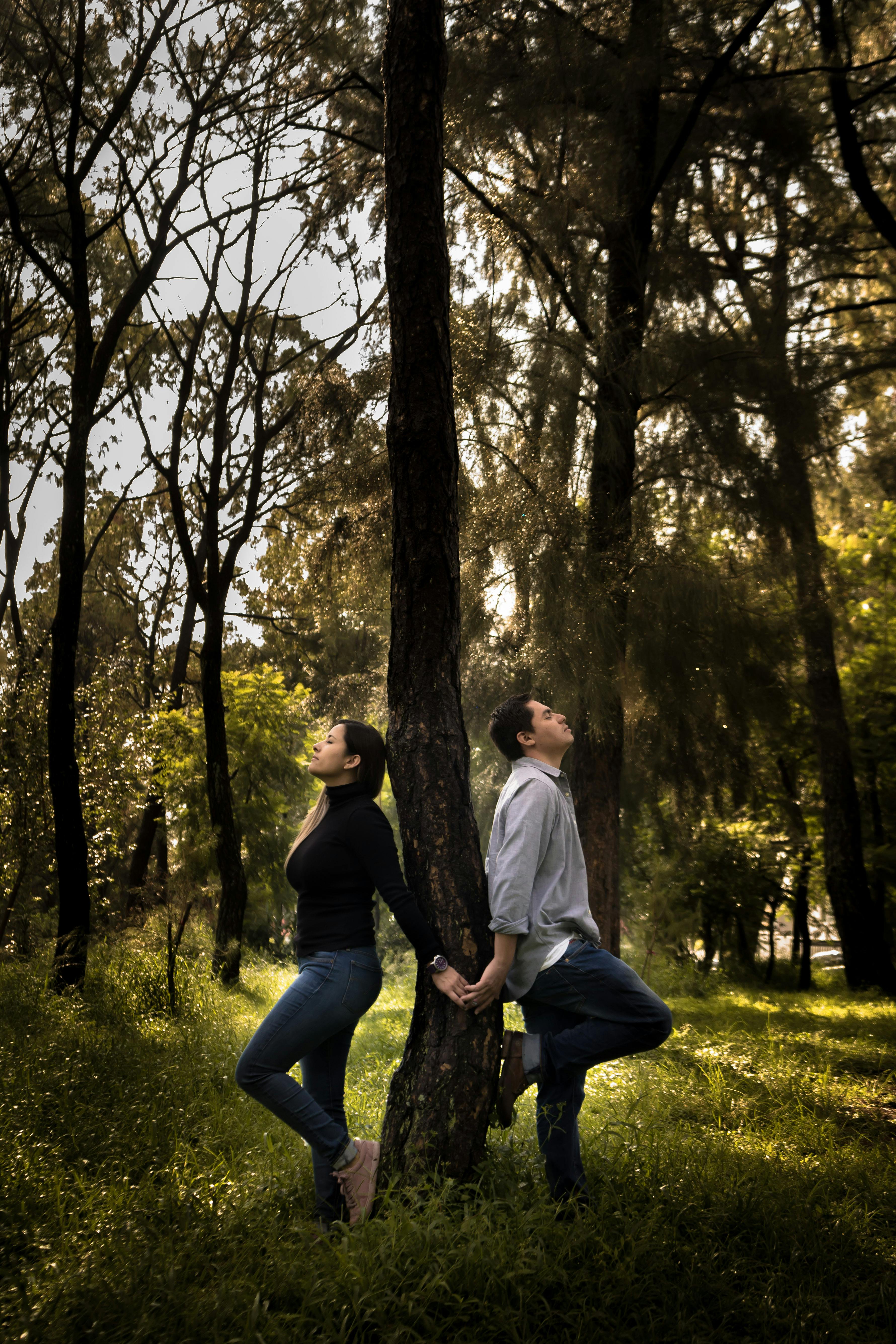 Couple Leaning on Tree in Forest