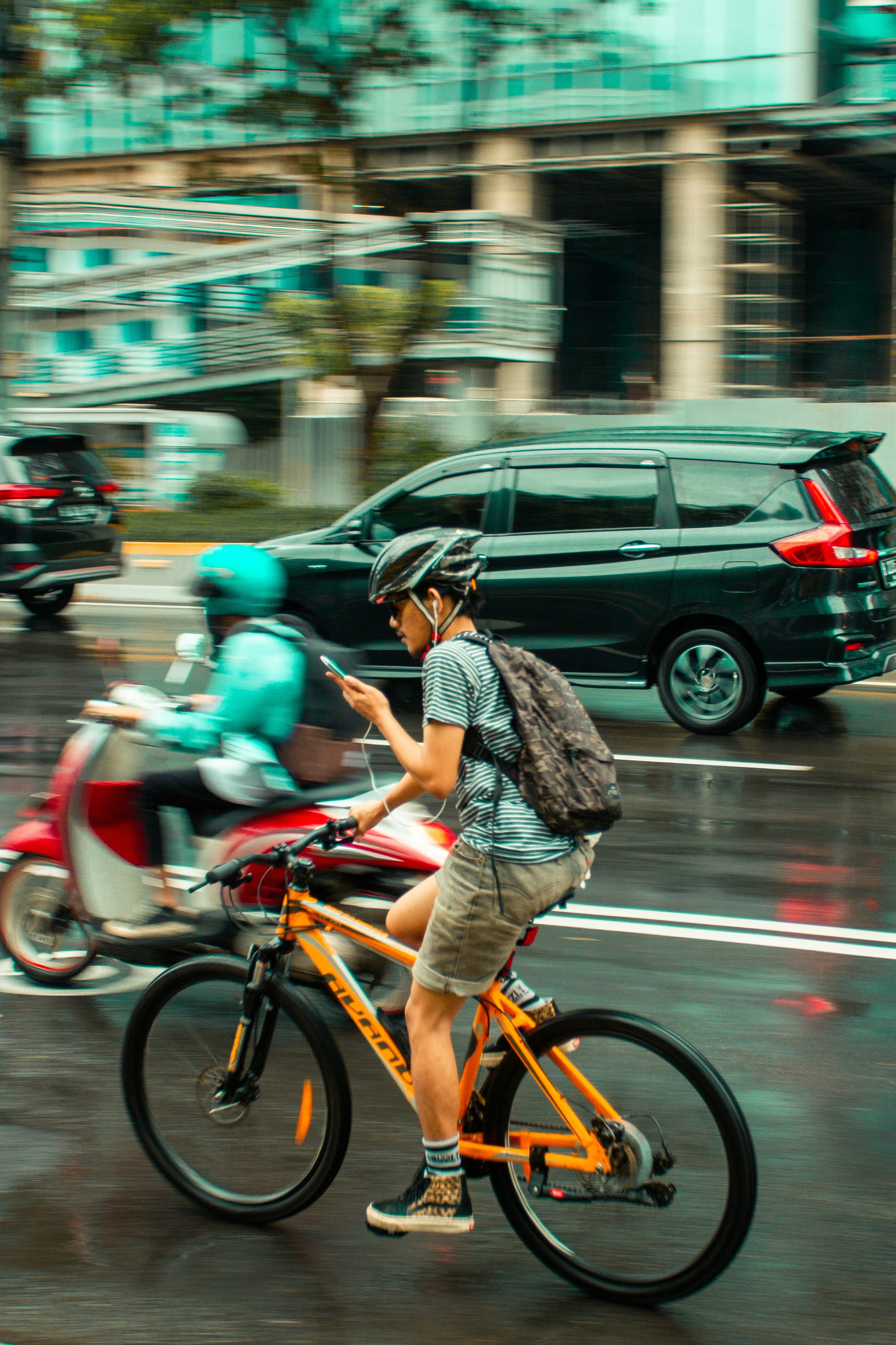 Cyclist Uses Phone While Cycling in City Traffic