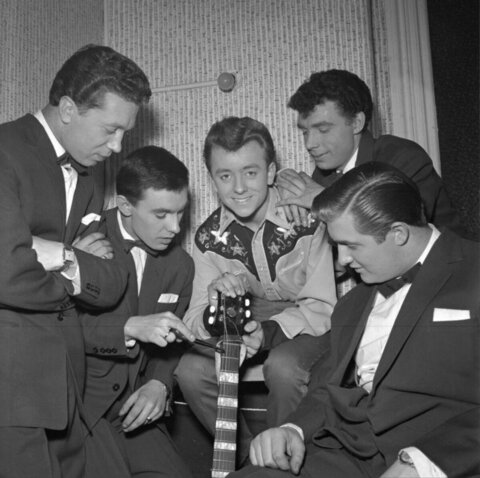 Five Musicians Gather Around a Guitar