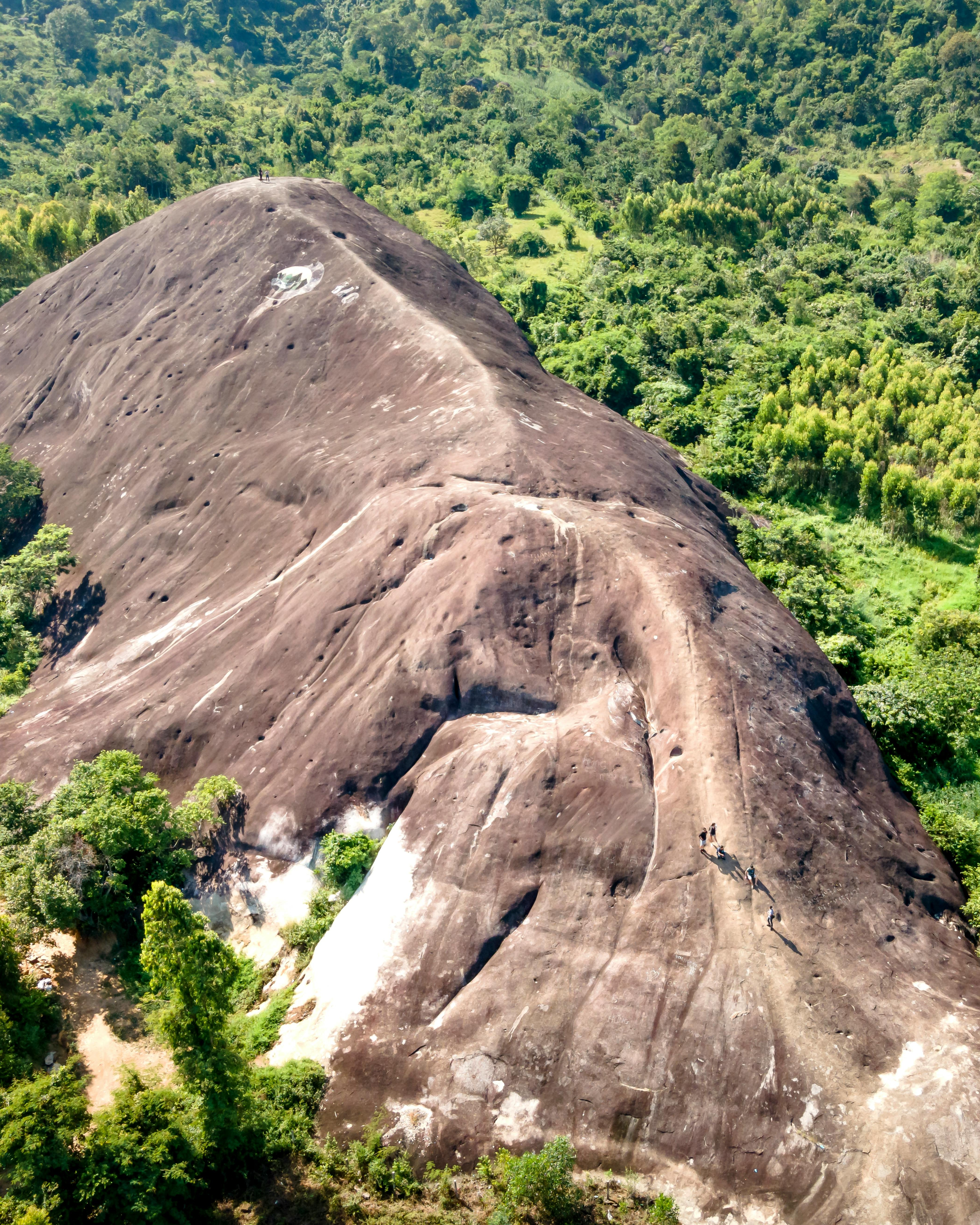 Hikers Climbing Giant Exposed Rock Hill