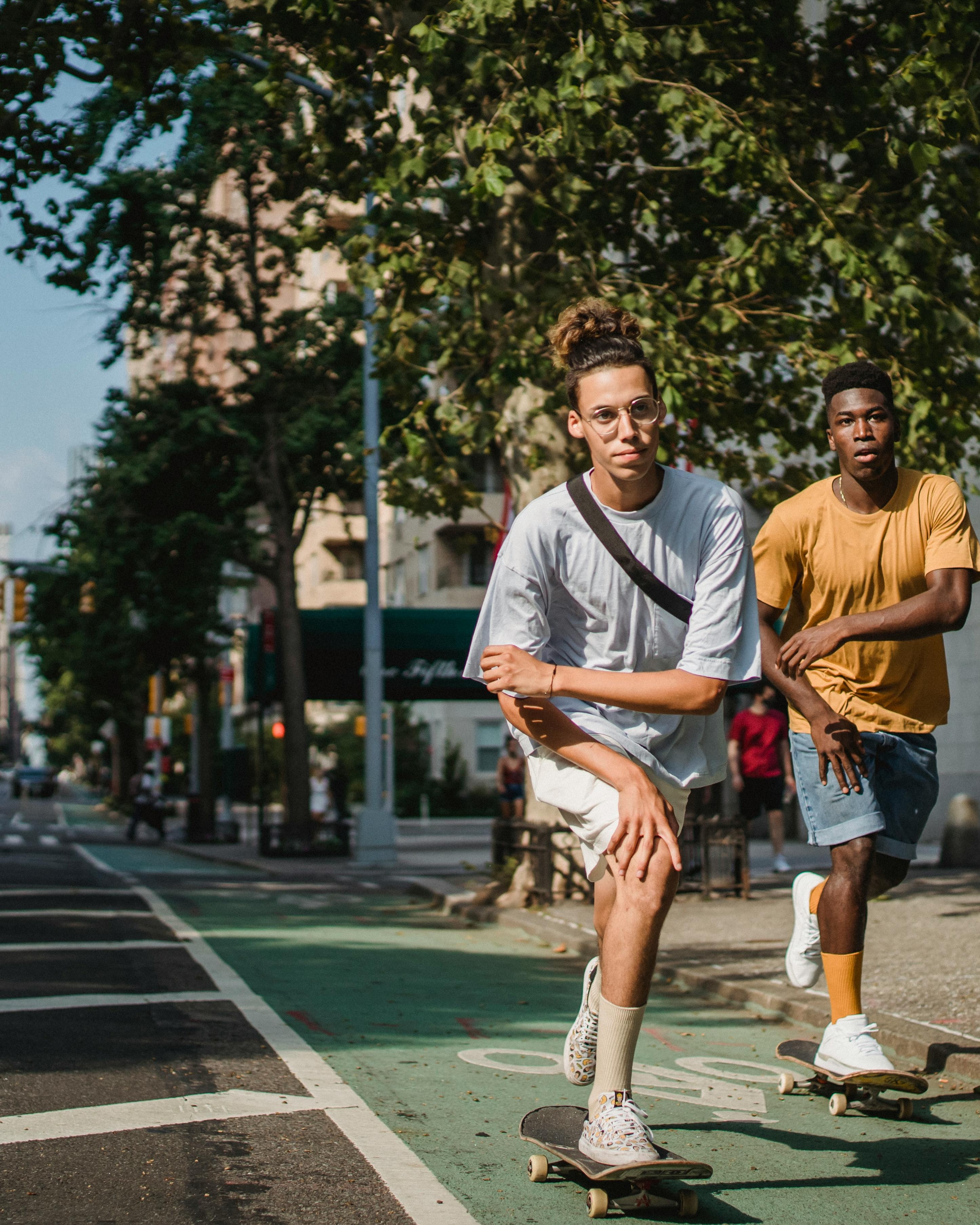 Two Young Men Skateboarding on City Street