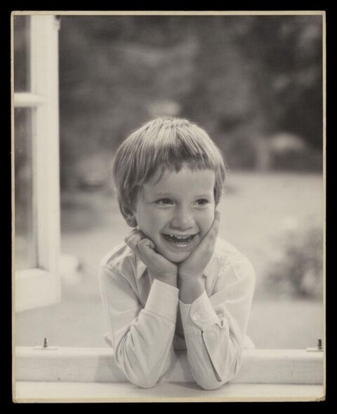 Smiling Boy Leaning on Window Sill