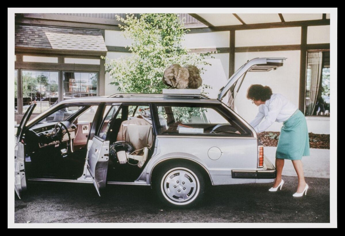 Woman Unloading Silver Station Wagon With Wigs