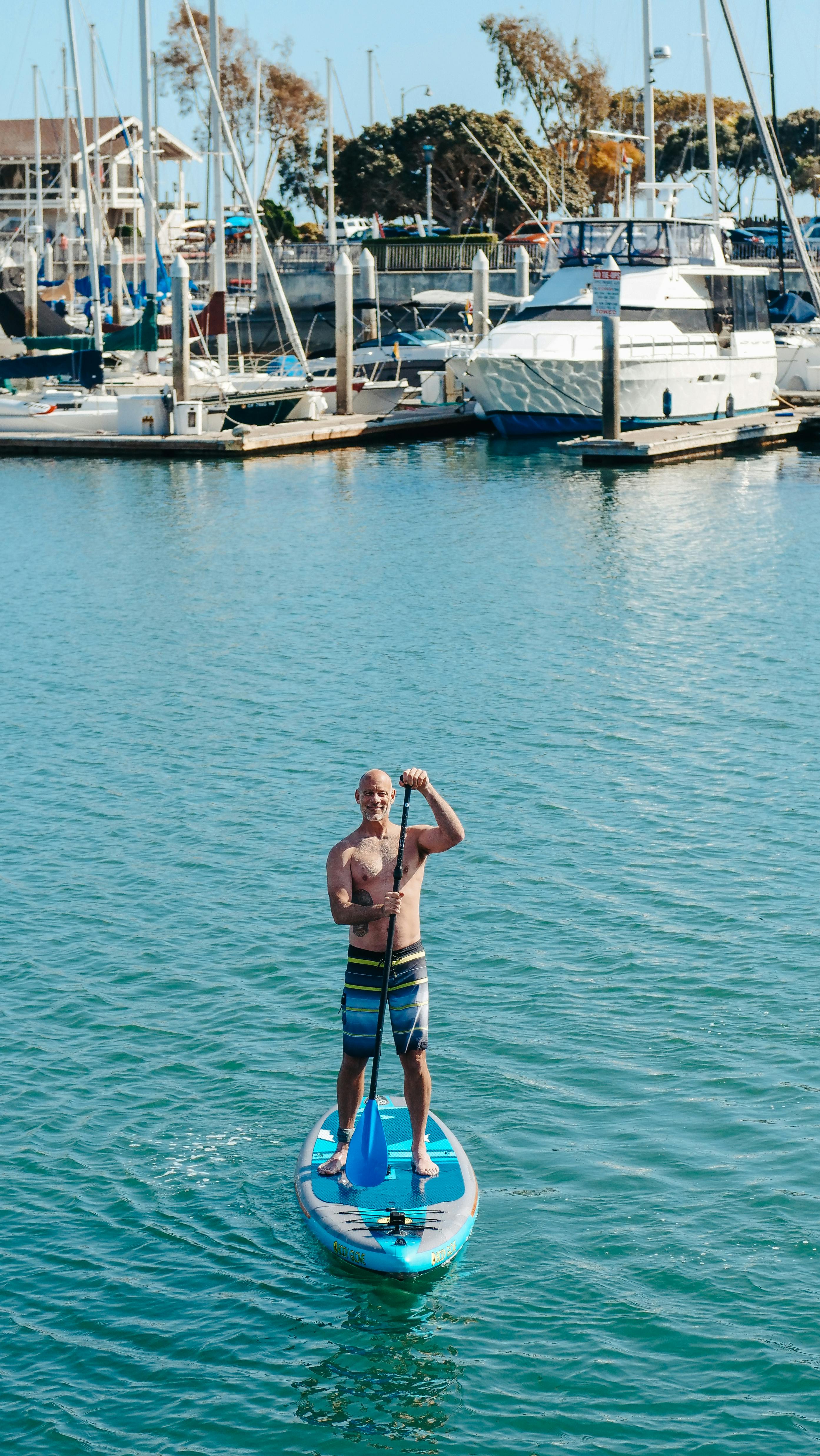 Man Paddleboarding in Marina Harbor