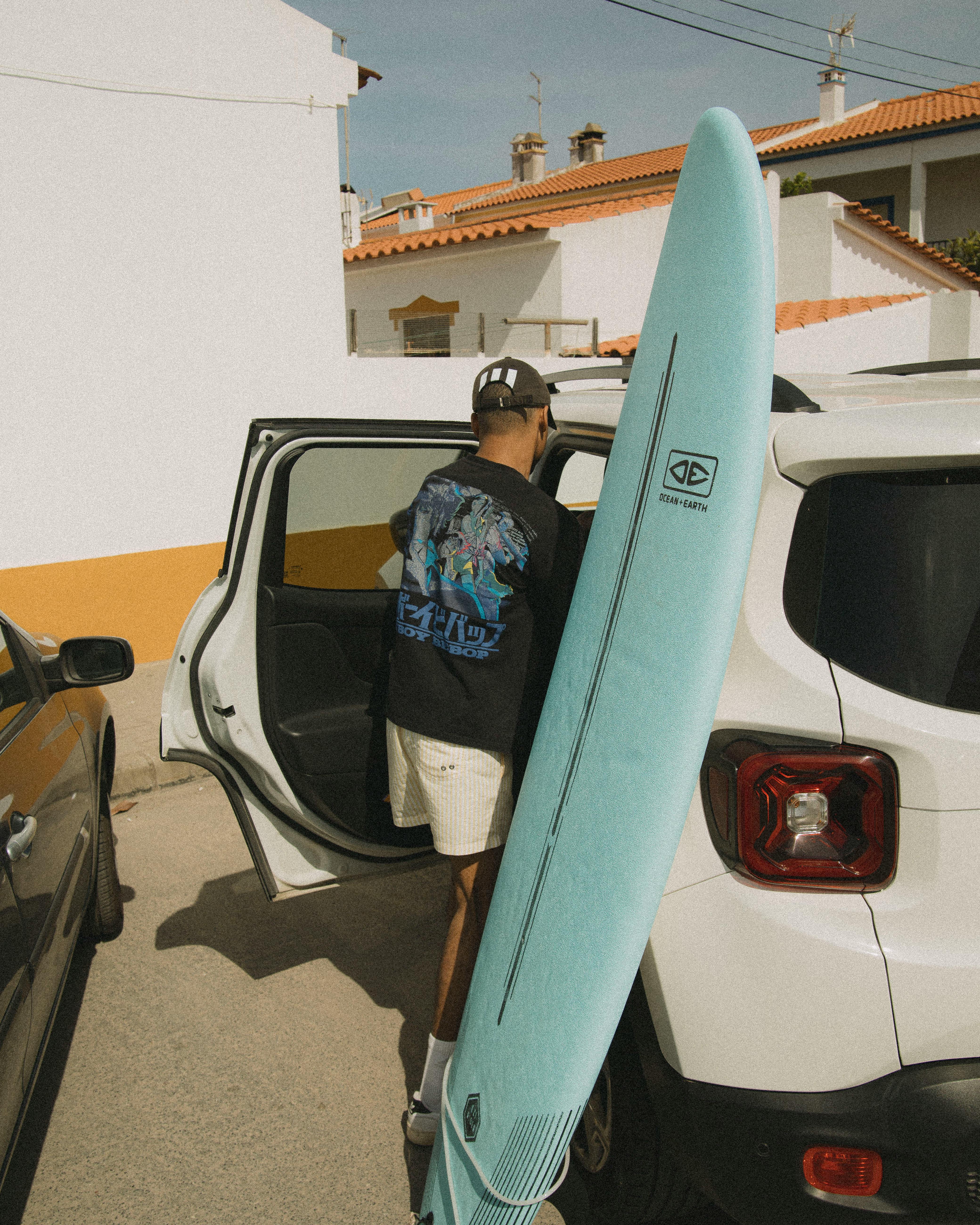 Surfer with Surfboard by Parked Car