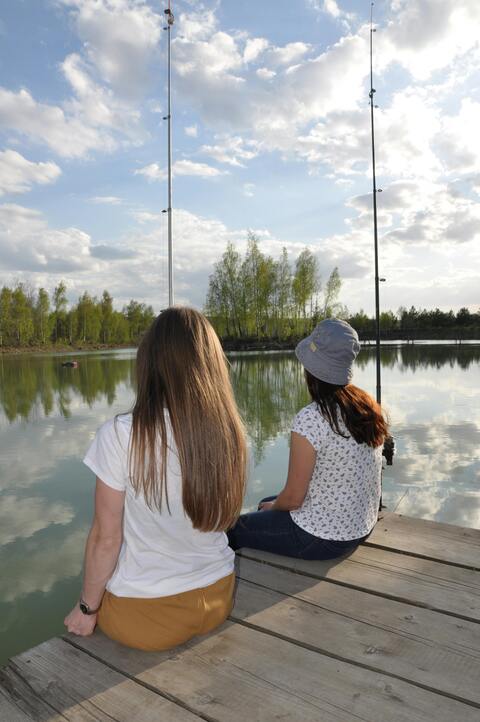 Two Women Fishing on a Lake Dock