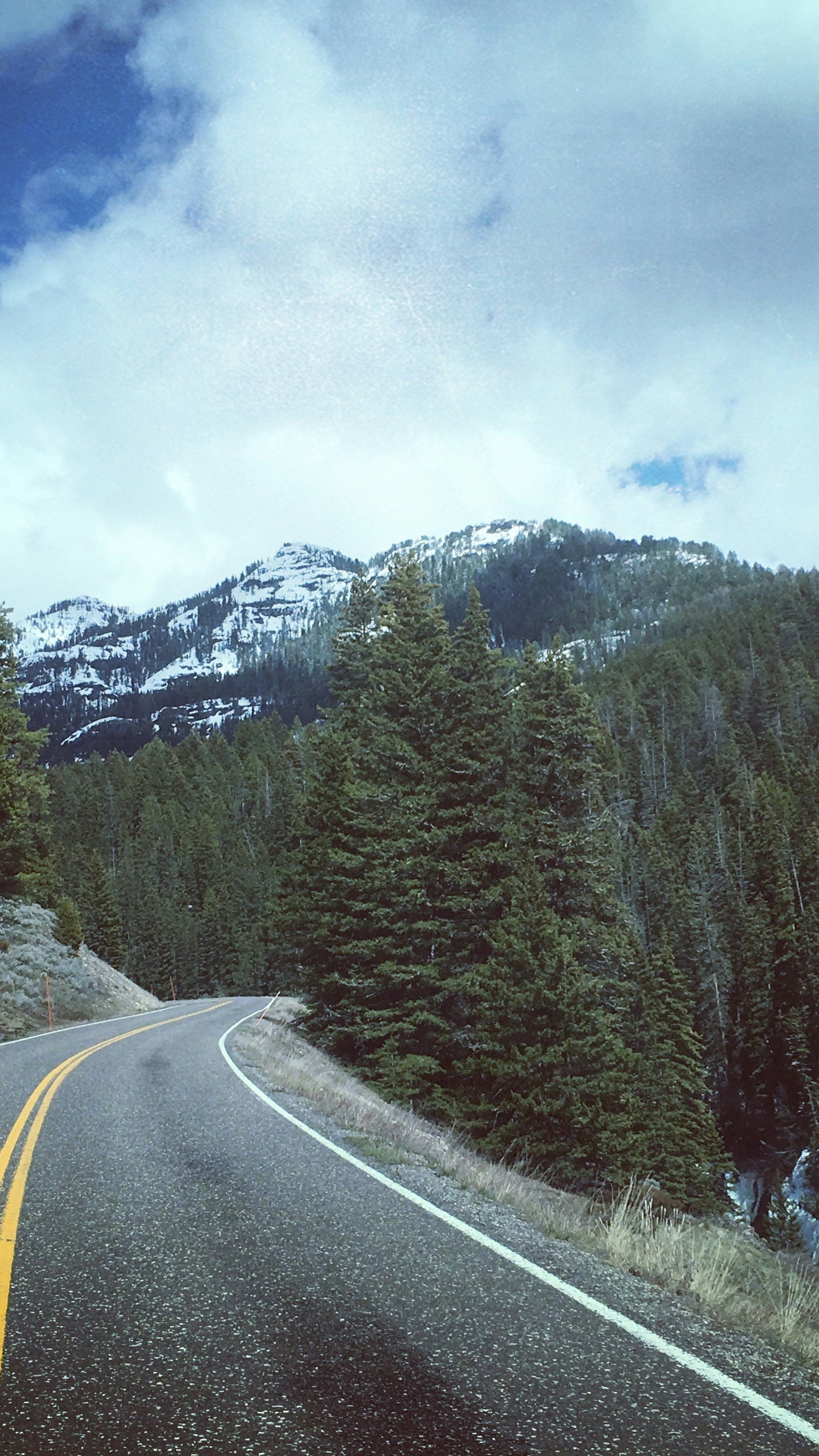 Winding Mountain Road Toward Snowy Peaks
