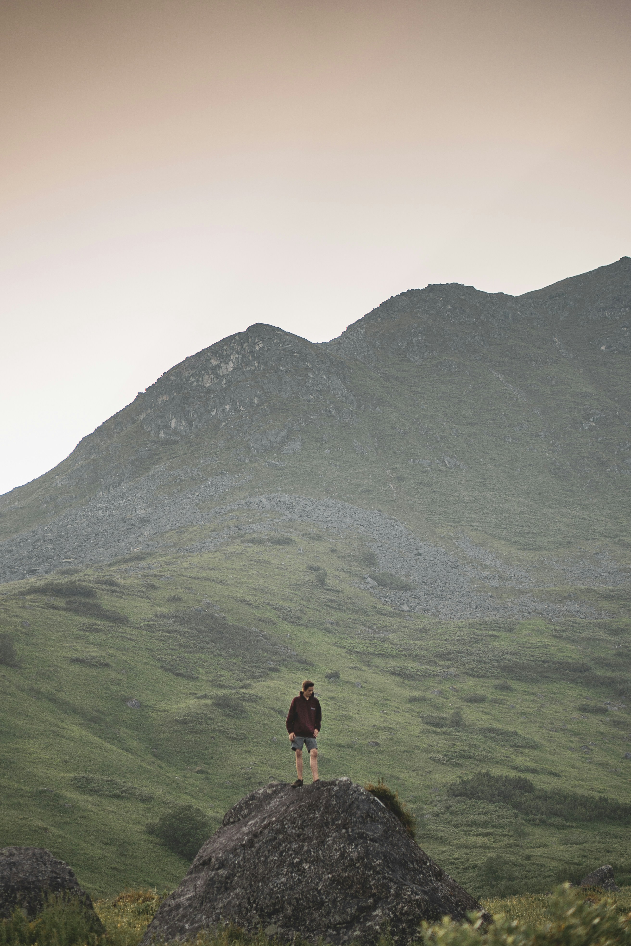 Hiker on Rock Amid Green Mountains