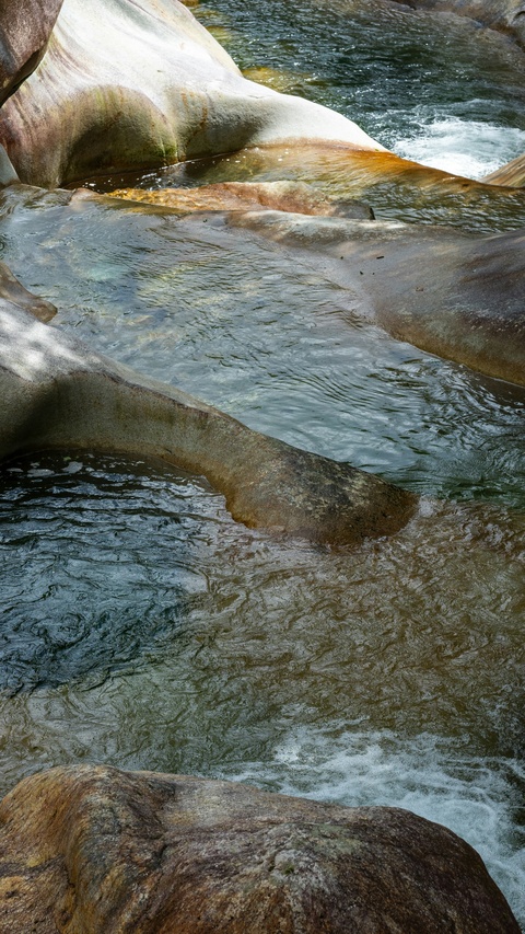 Clear River Flowing Over Smooth Rocks