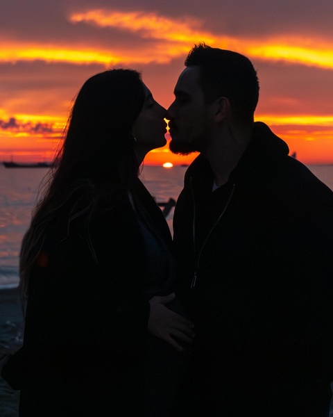 Couple Kissing By Sea At Sunset