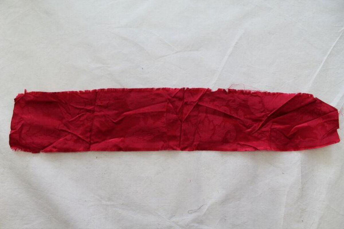Crumpled Red Fabric Strip on White Background