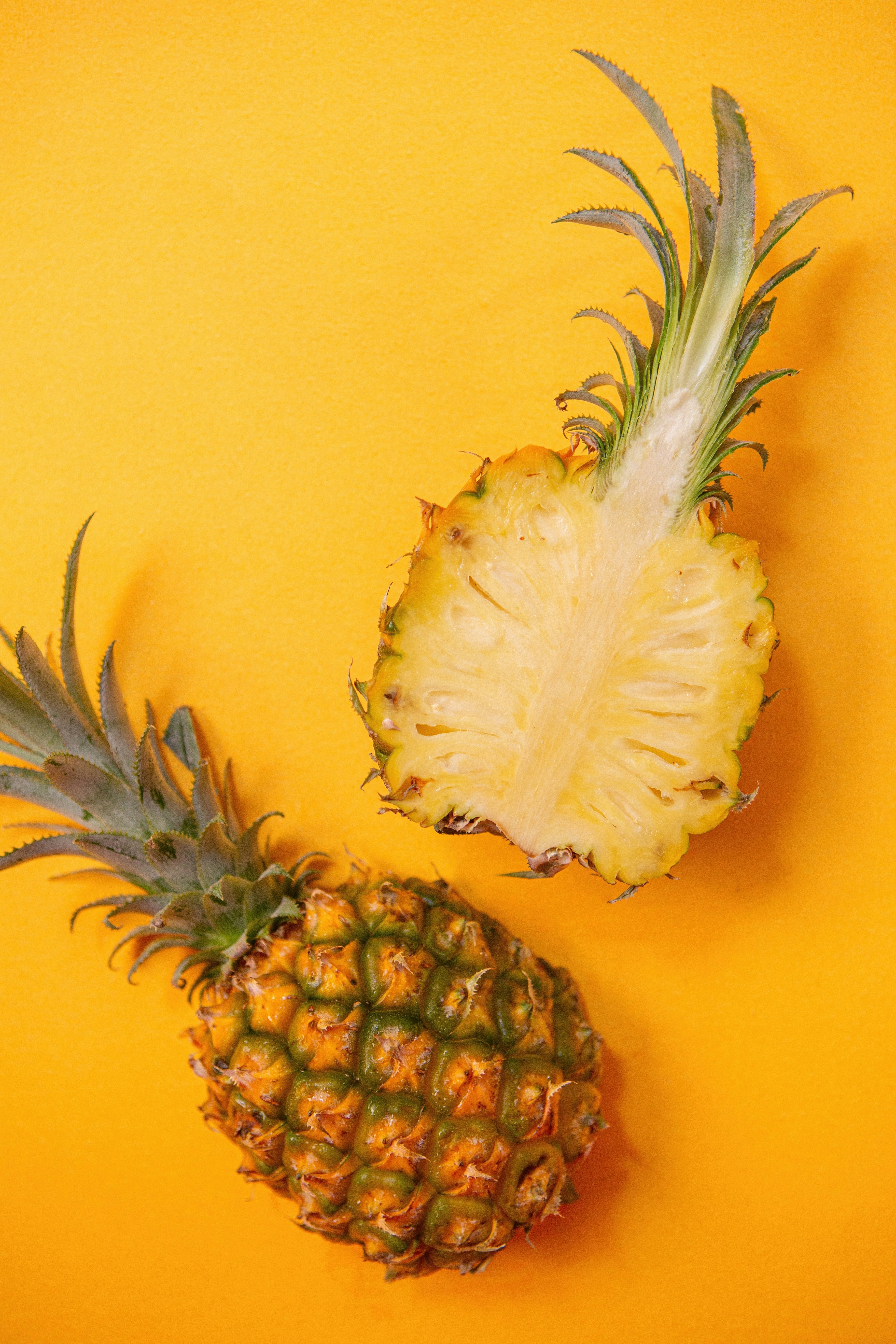 Cut and Whole Pineapples on Yellow Background — Fruit Encyclopedia