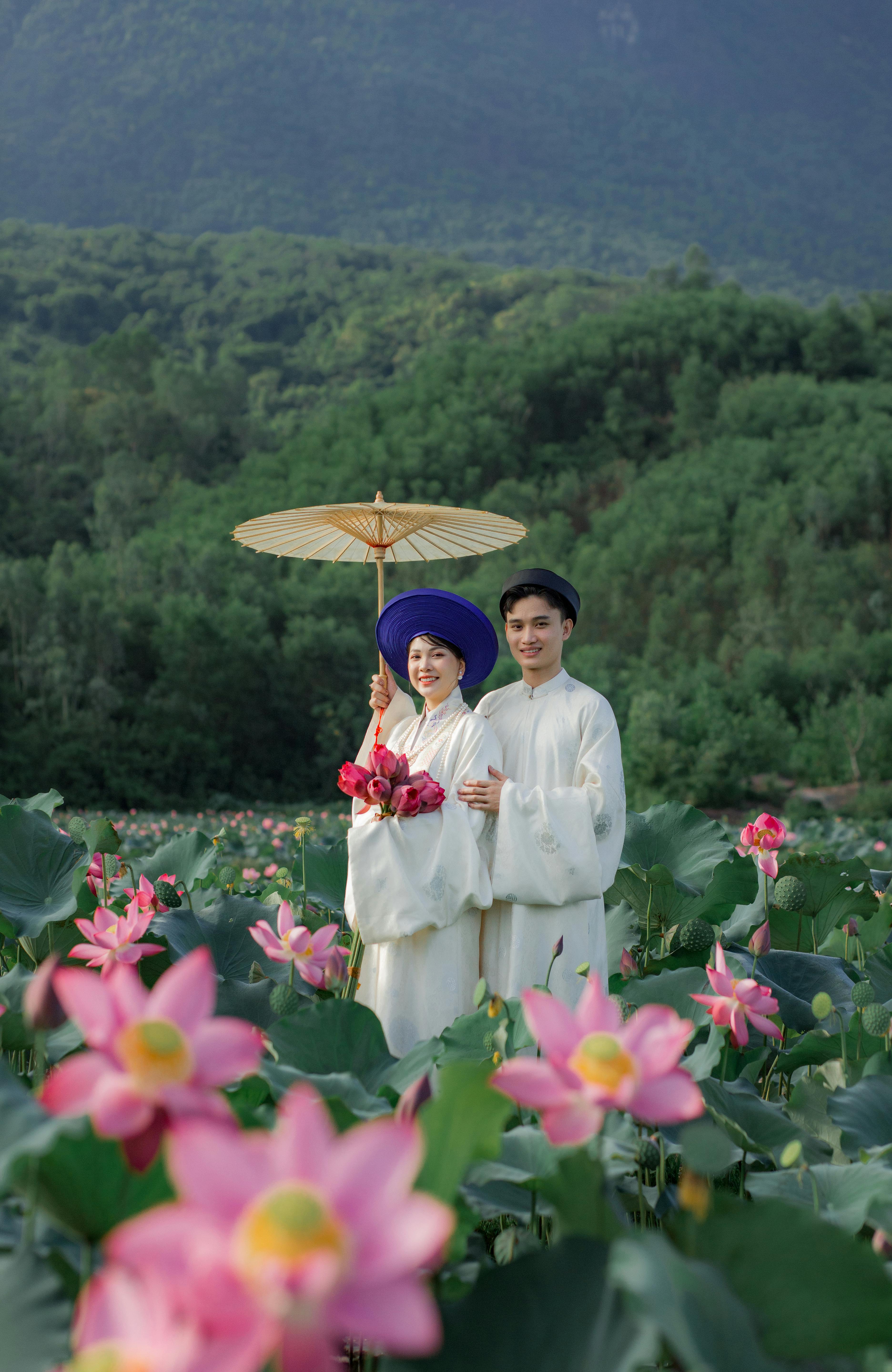 Couple in Traditional Attire in Lotus Field
