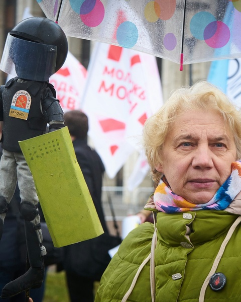 Woman at Protest Holding Riot Police Effigy