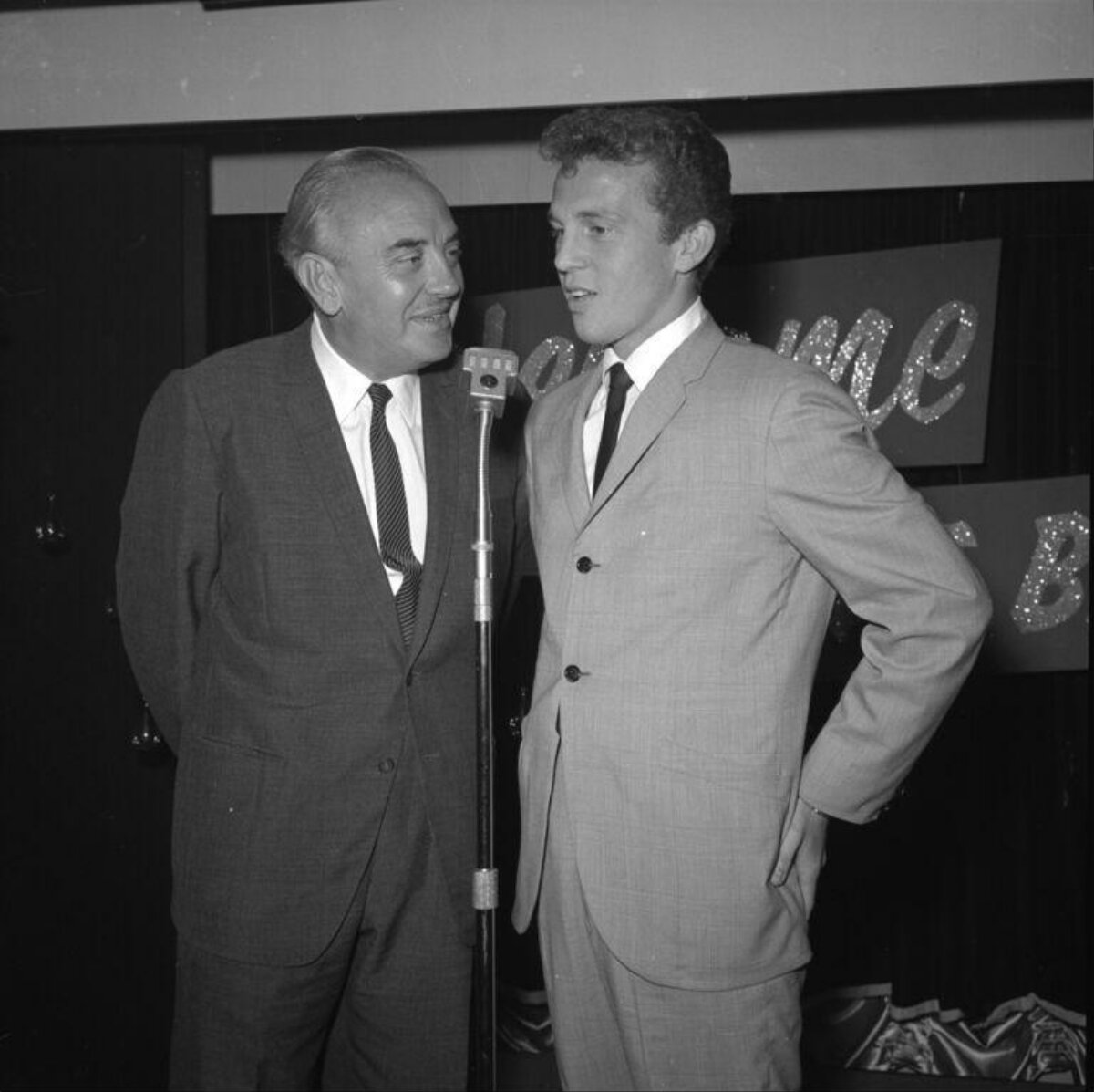 Two Men In Suits By Event Microphone