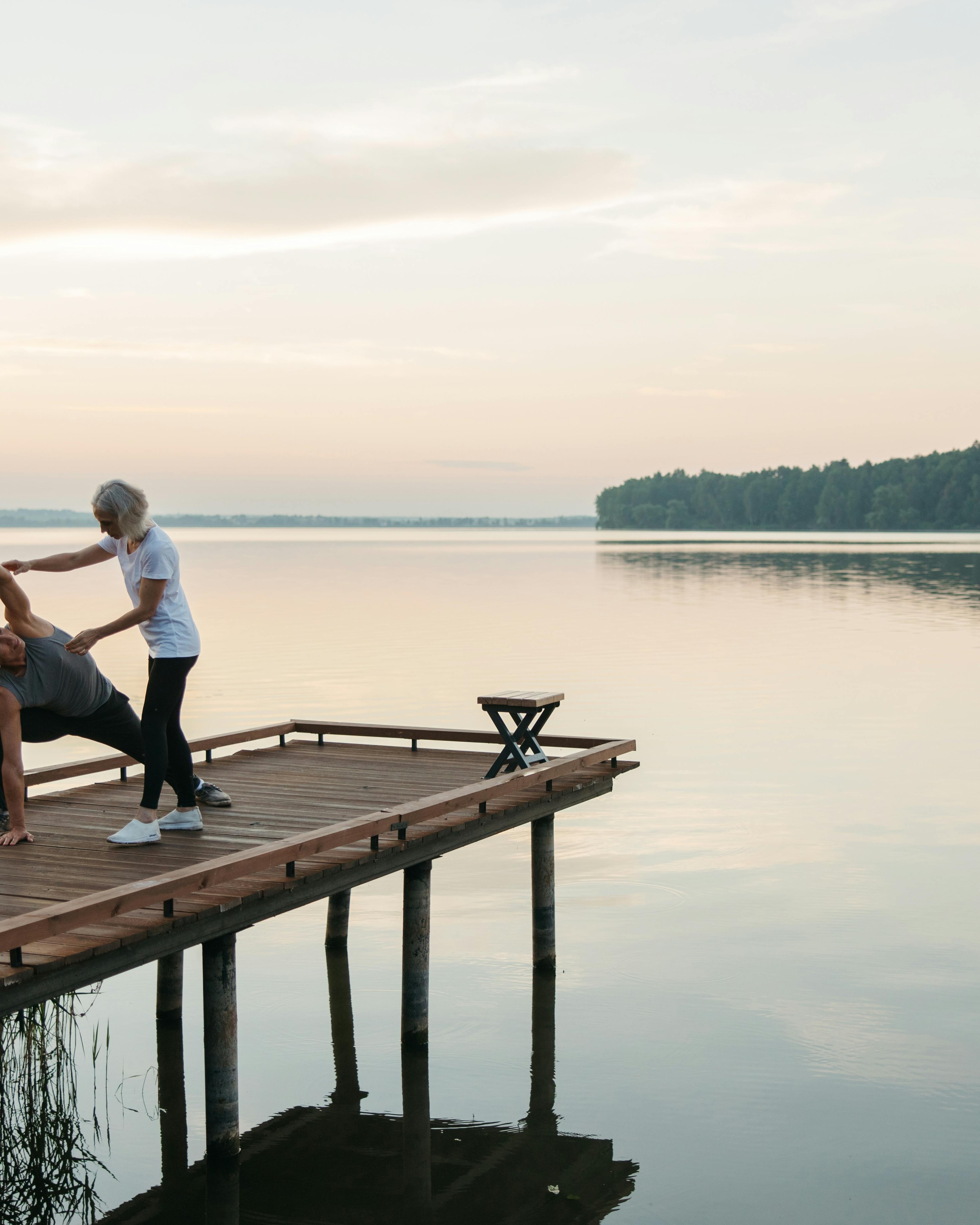 Couple Stretching on Lake Dock