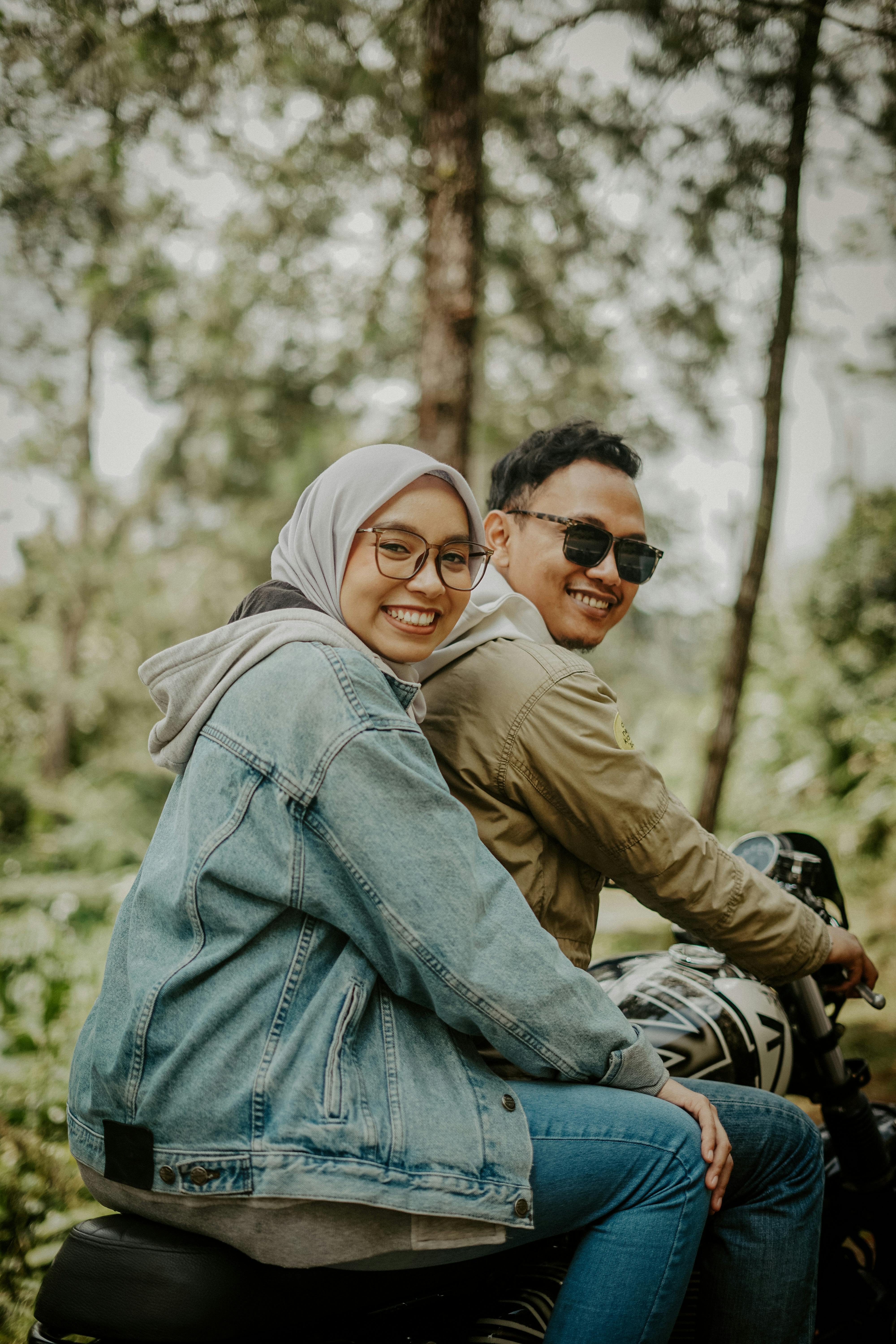 Smiling Couple on Motorcycle in Forest