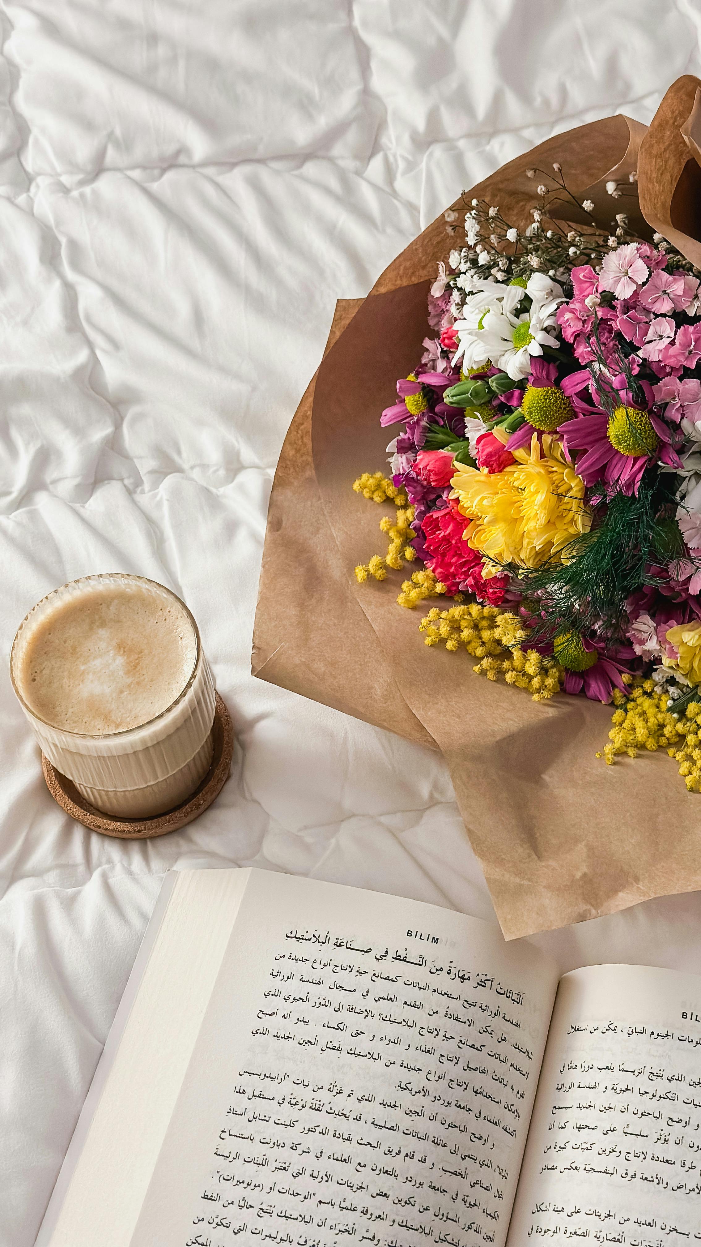 Bouquet, Coffee and Open Book on Bed