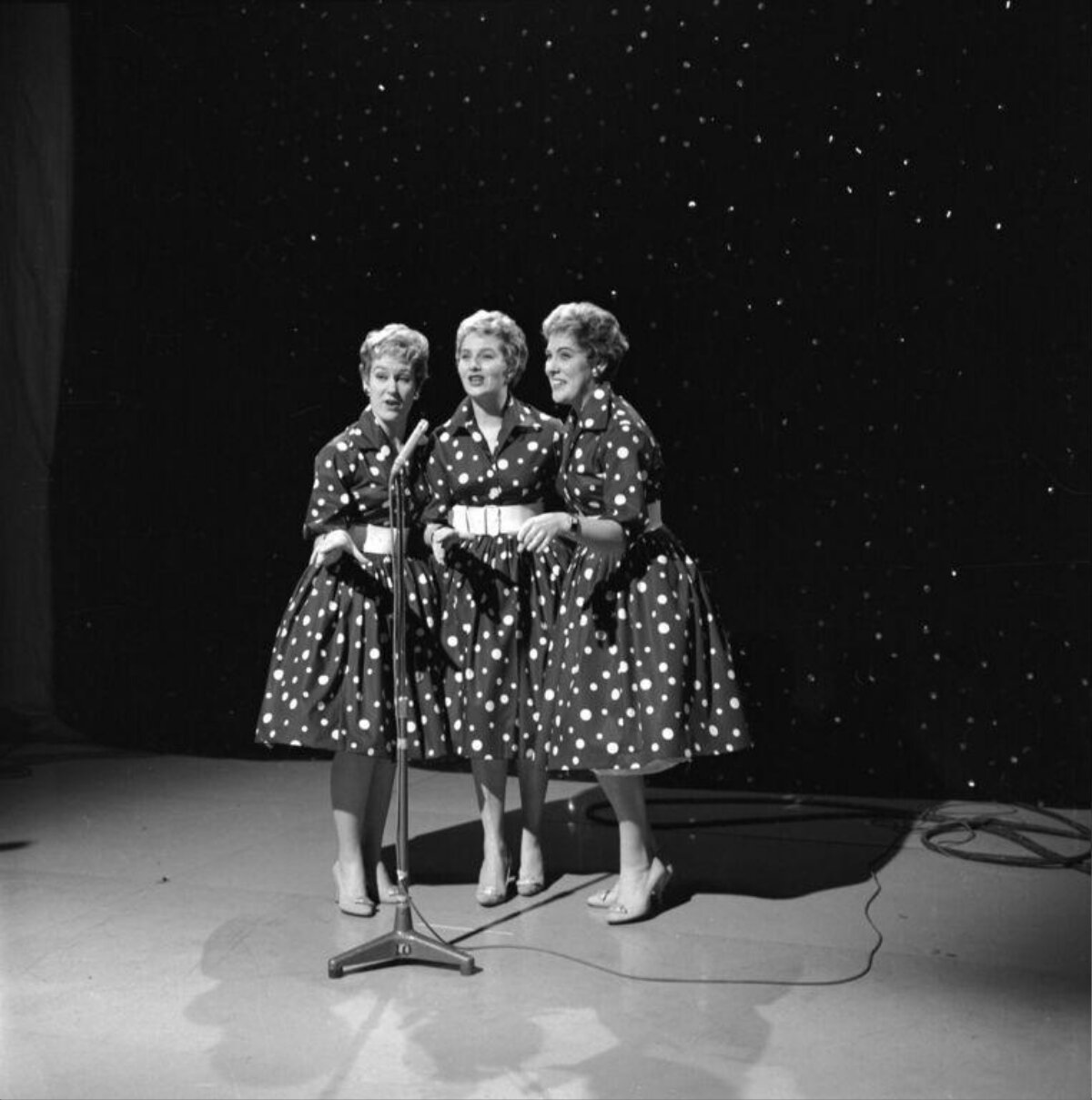 Three Singers Performing On Stage