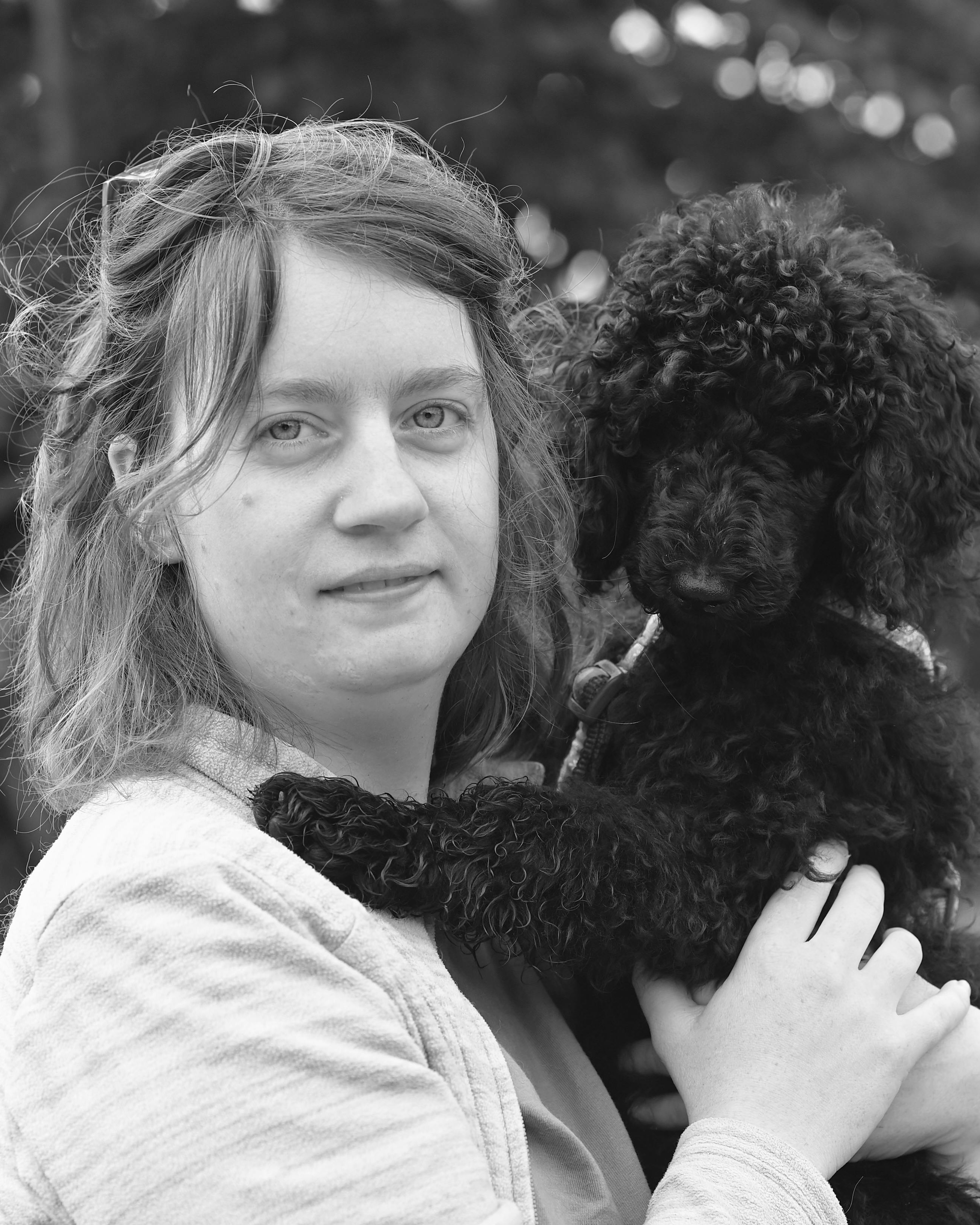 Woman Holding a Curly Poodle Puppy