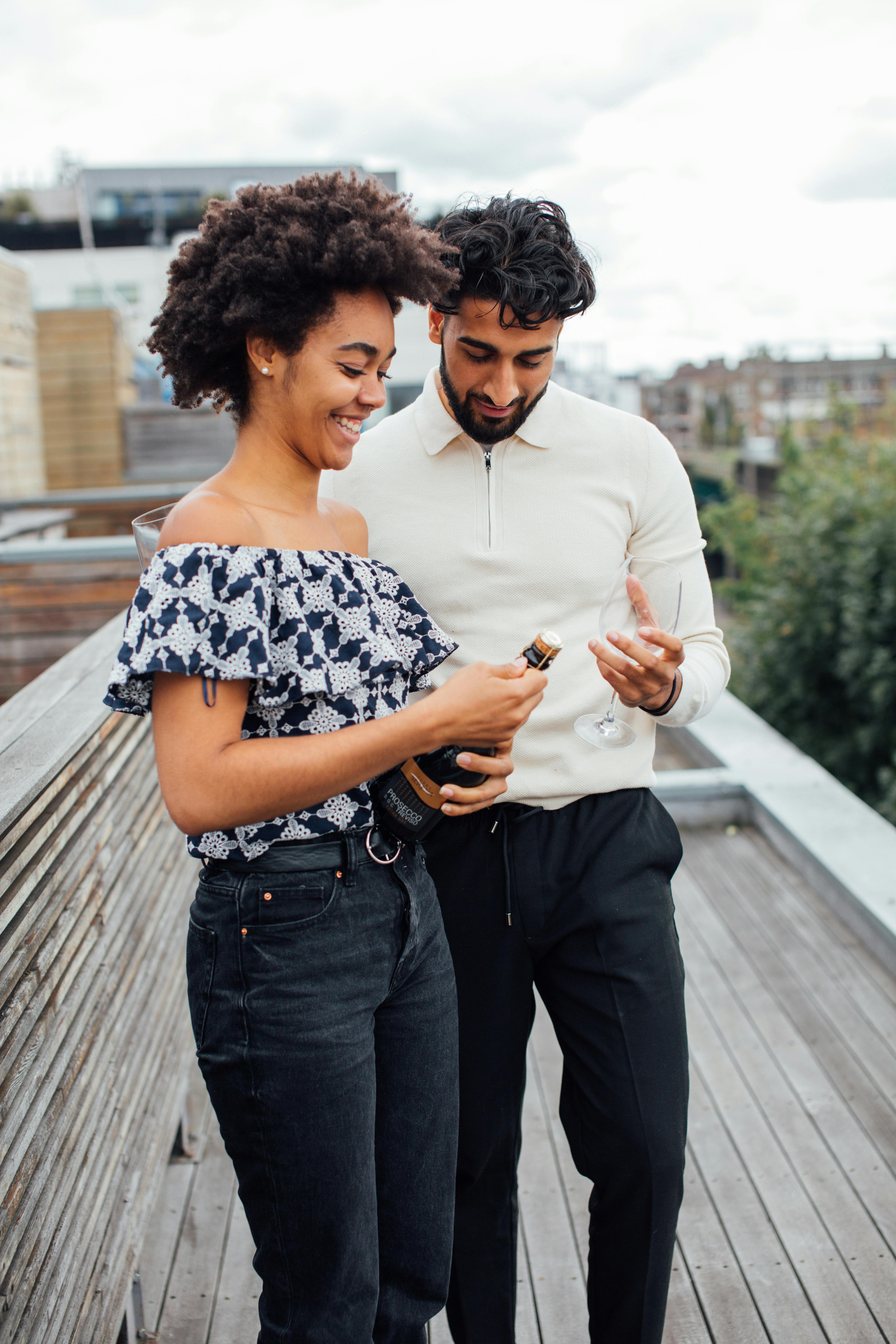 Couple Opening Wine on Rooftop Terrace