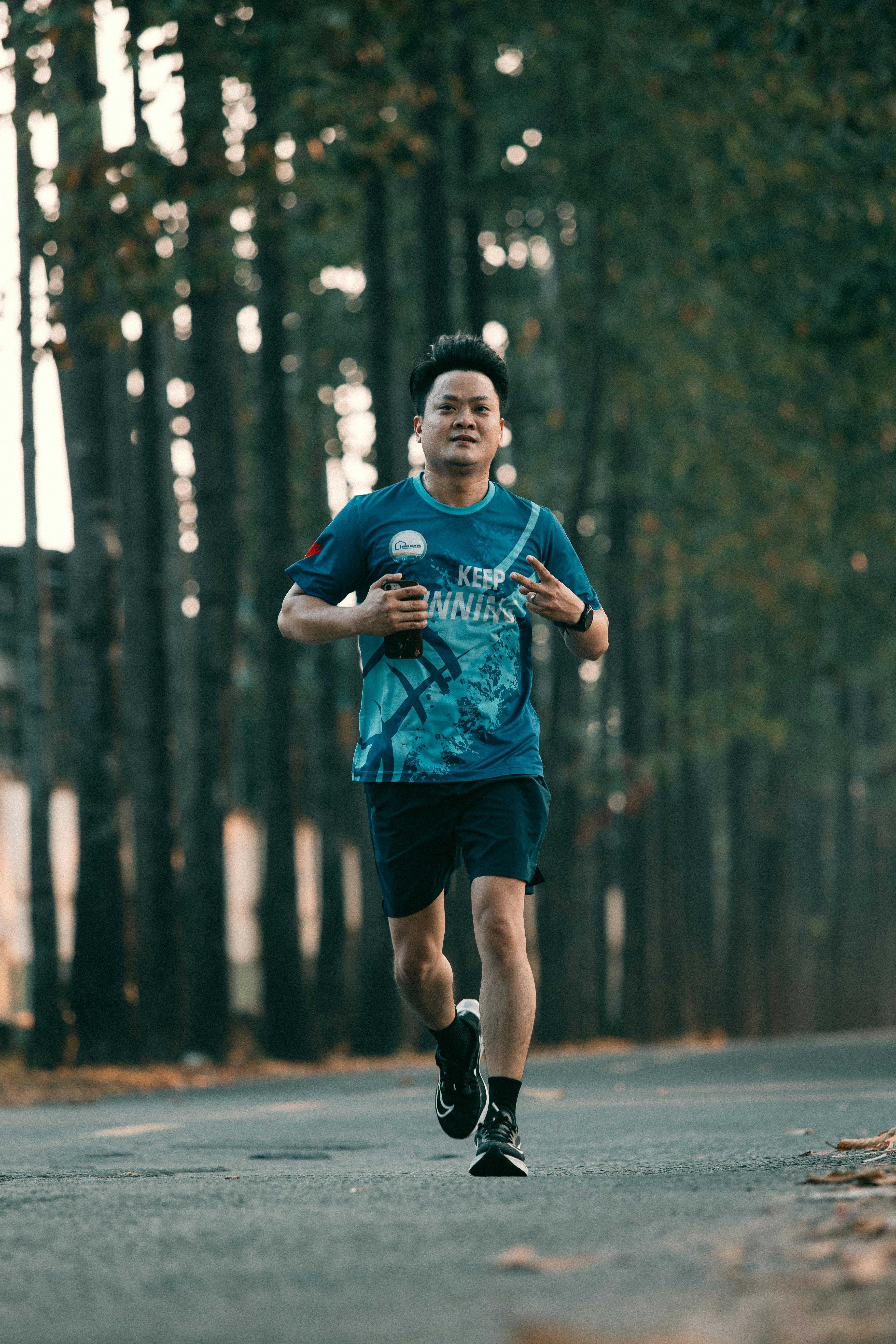 Man Jogging on Tree-Lined Road