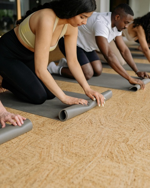 Group Rolling Up Yoga Mats After Class
