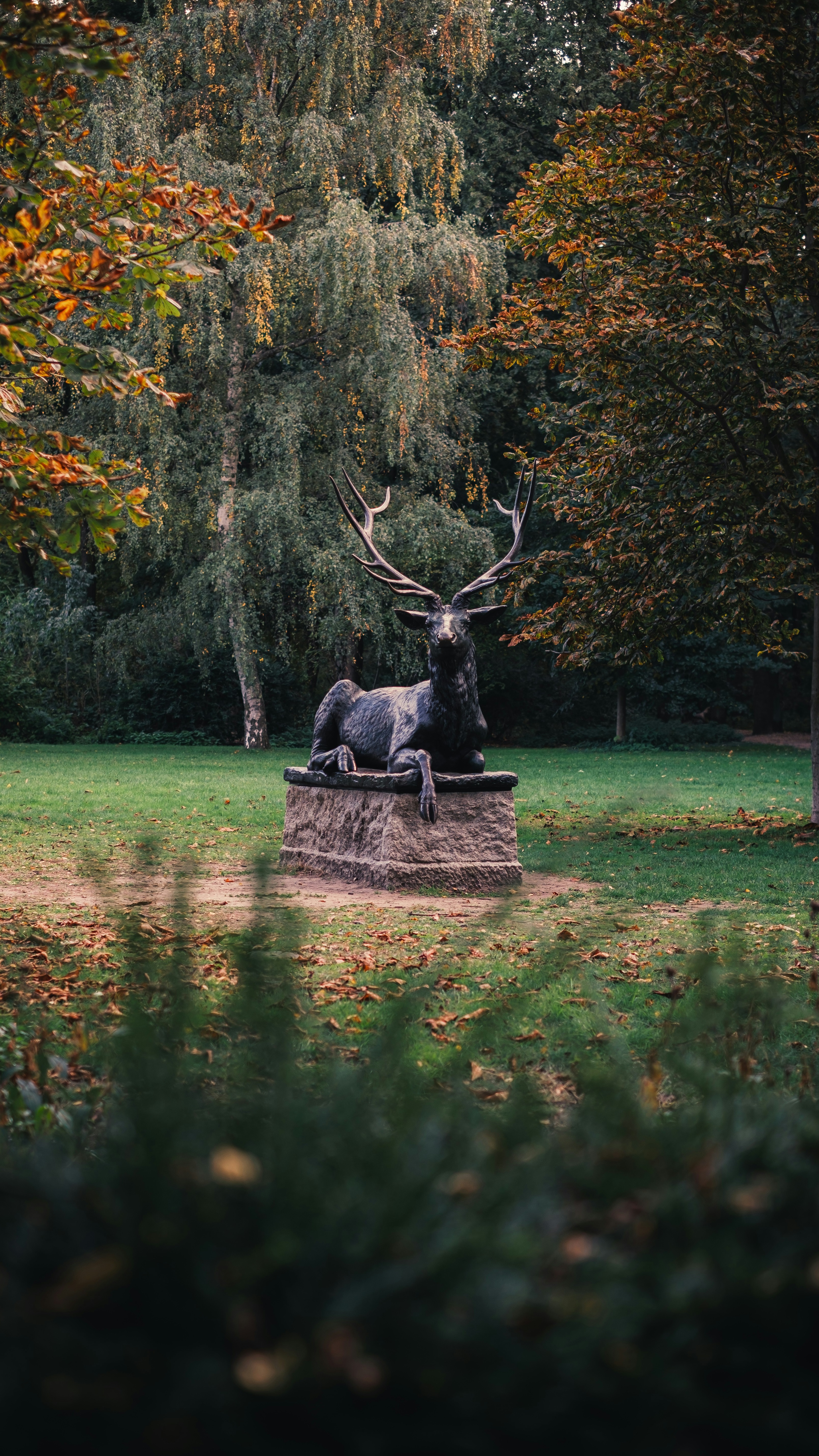 Reclining Stag Statue in Autumn Park