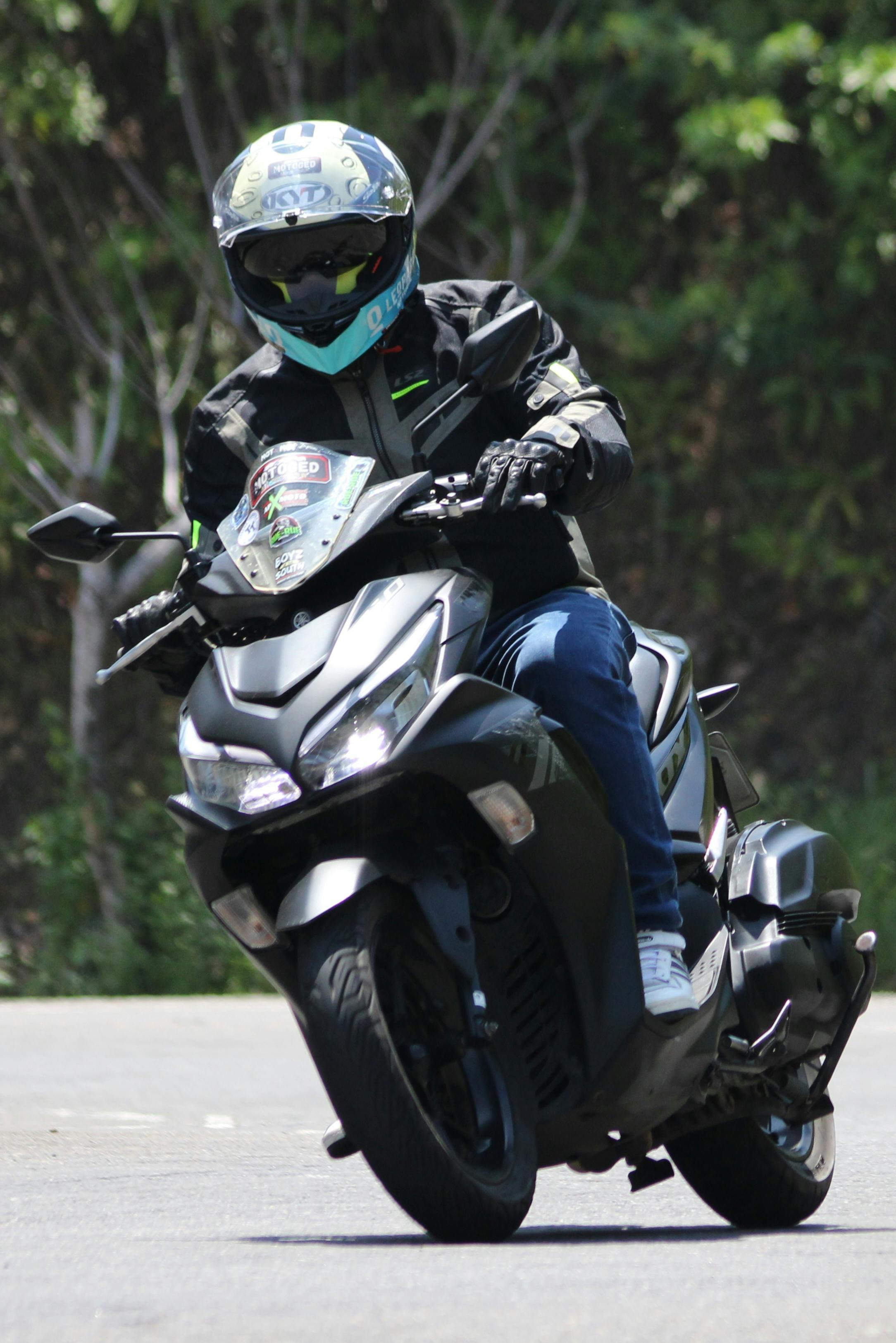 Motorcyclist Riding Scooter on Road