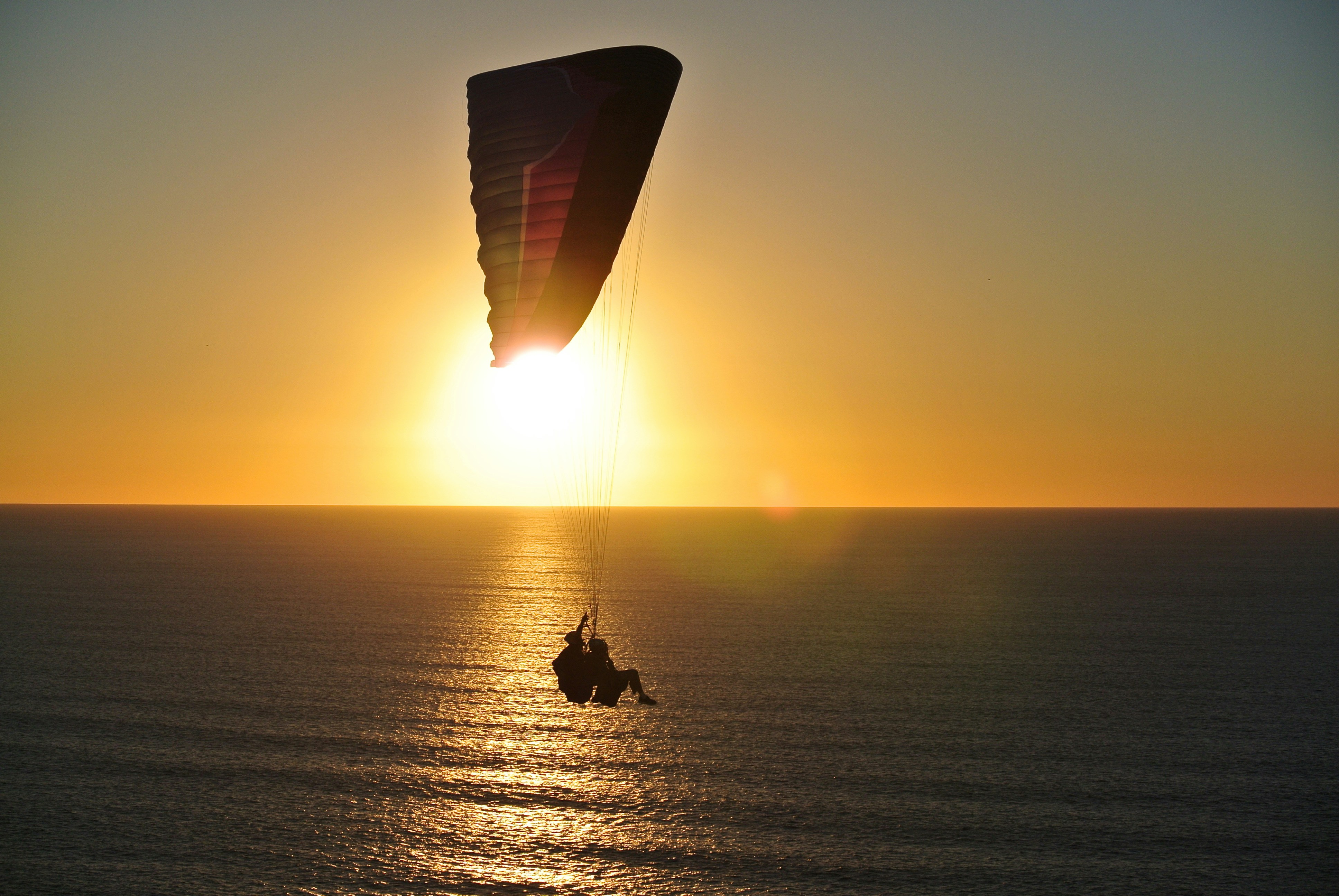 Paragliding Over Sea At Sunset