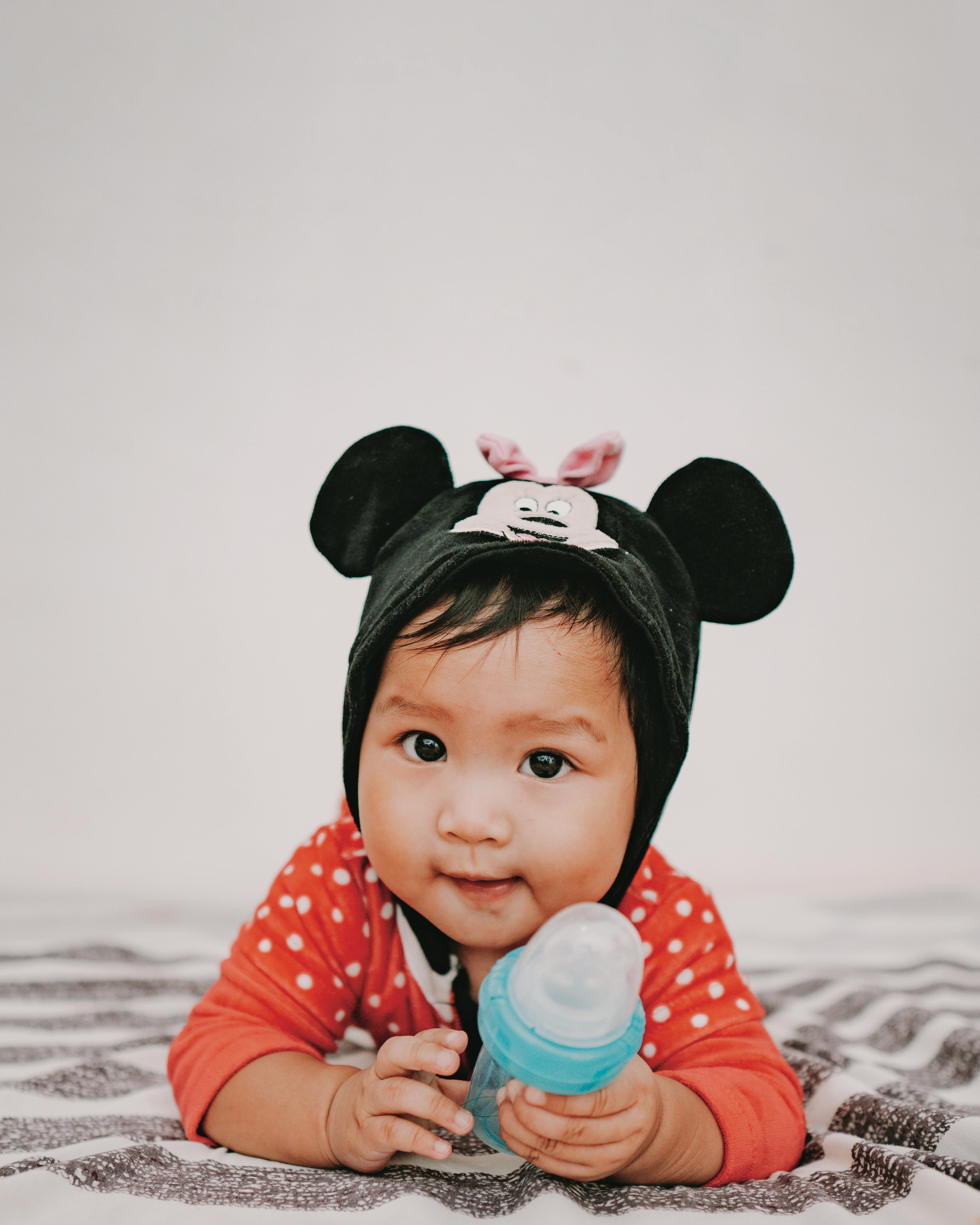Baby in Minnie Costume Holding Baby Bottle