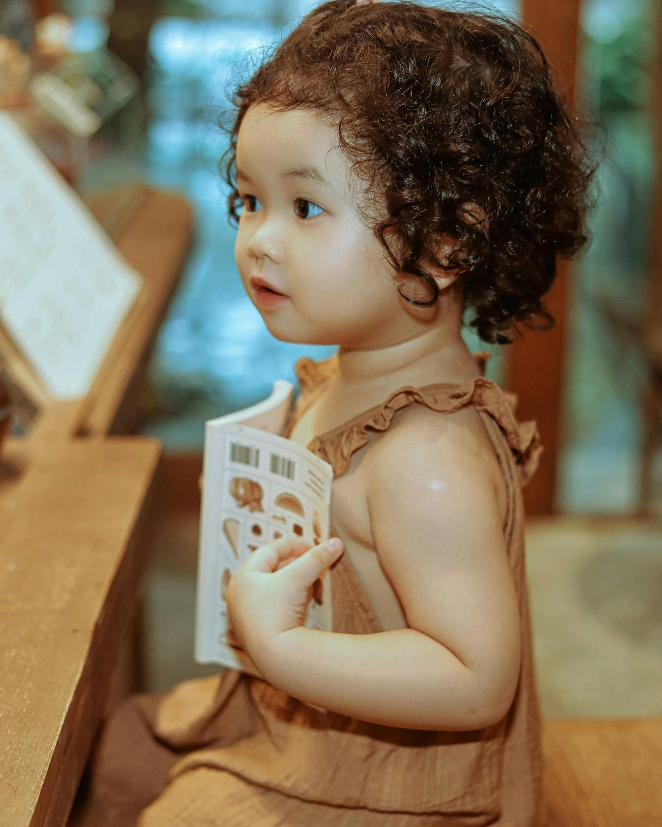 Curly Haired Toddler Holding a Book