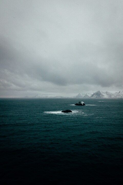 Overcast Sea With Distant Snowy Mountains