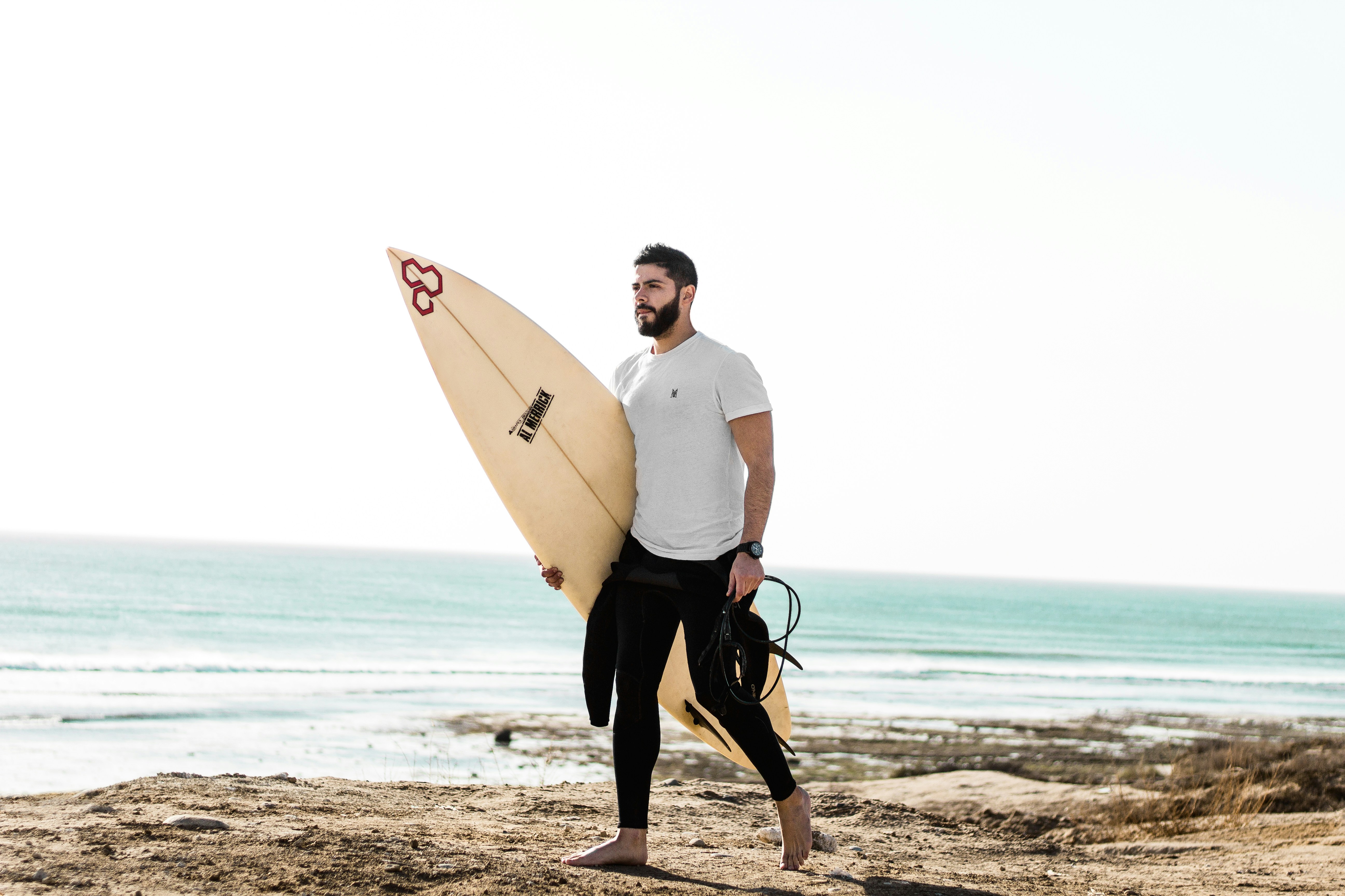 Surfer Carrying Surfboard at Beach