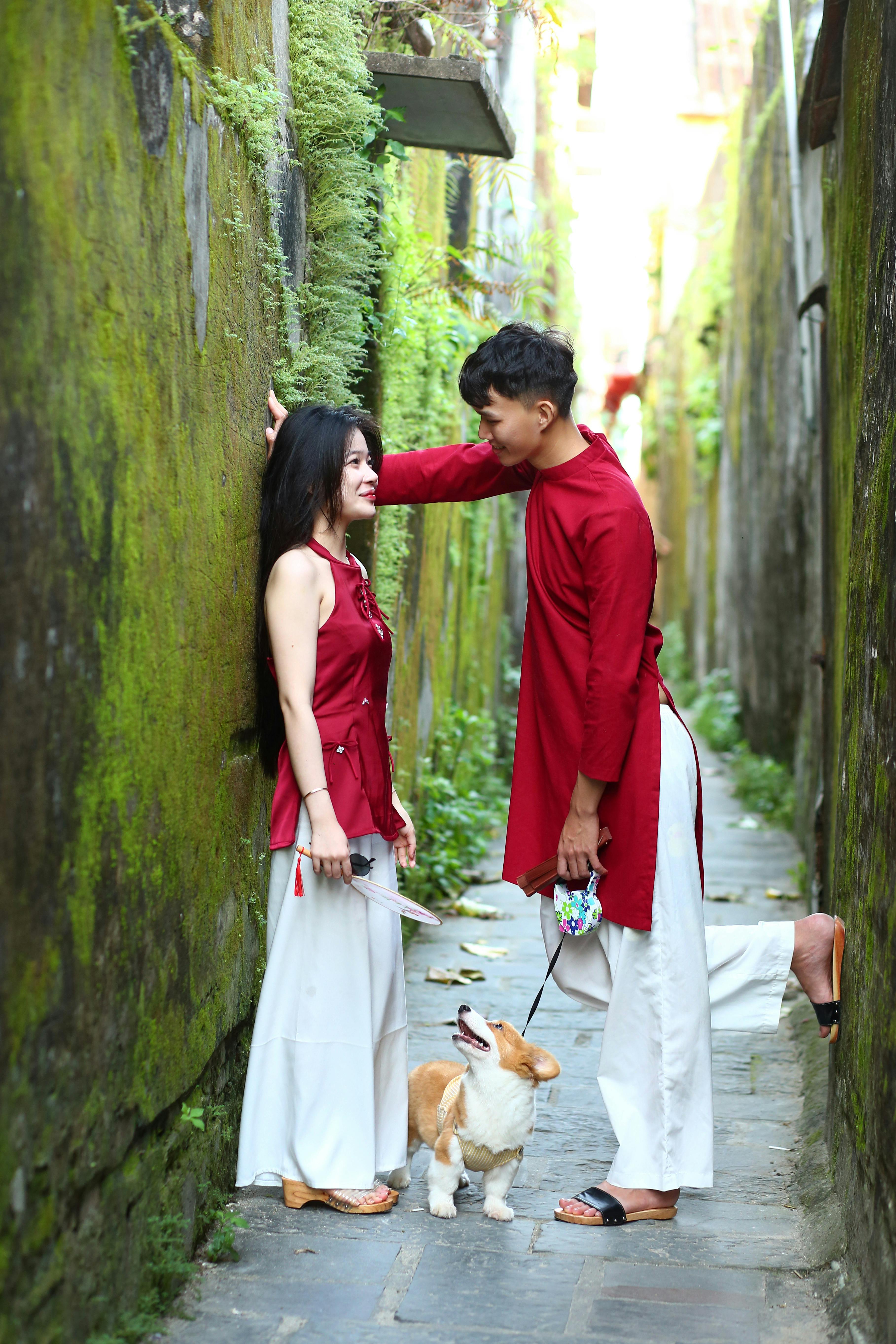 Couple and corgi in narrow mossy alley