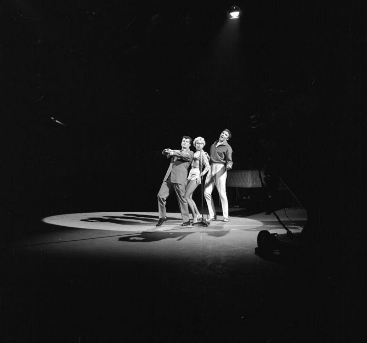 Three Performers Under Spotlight on Stage