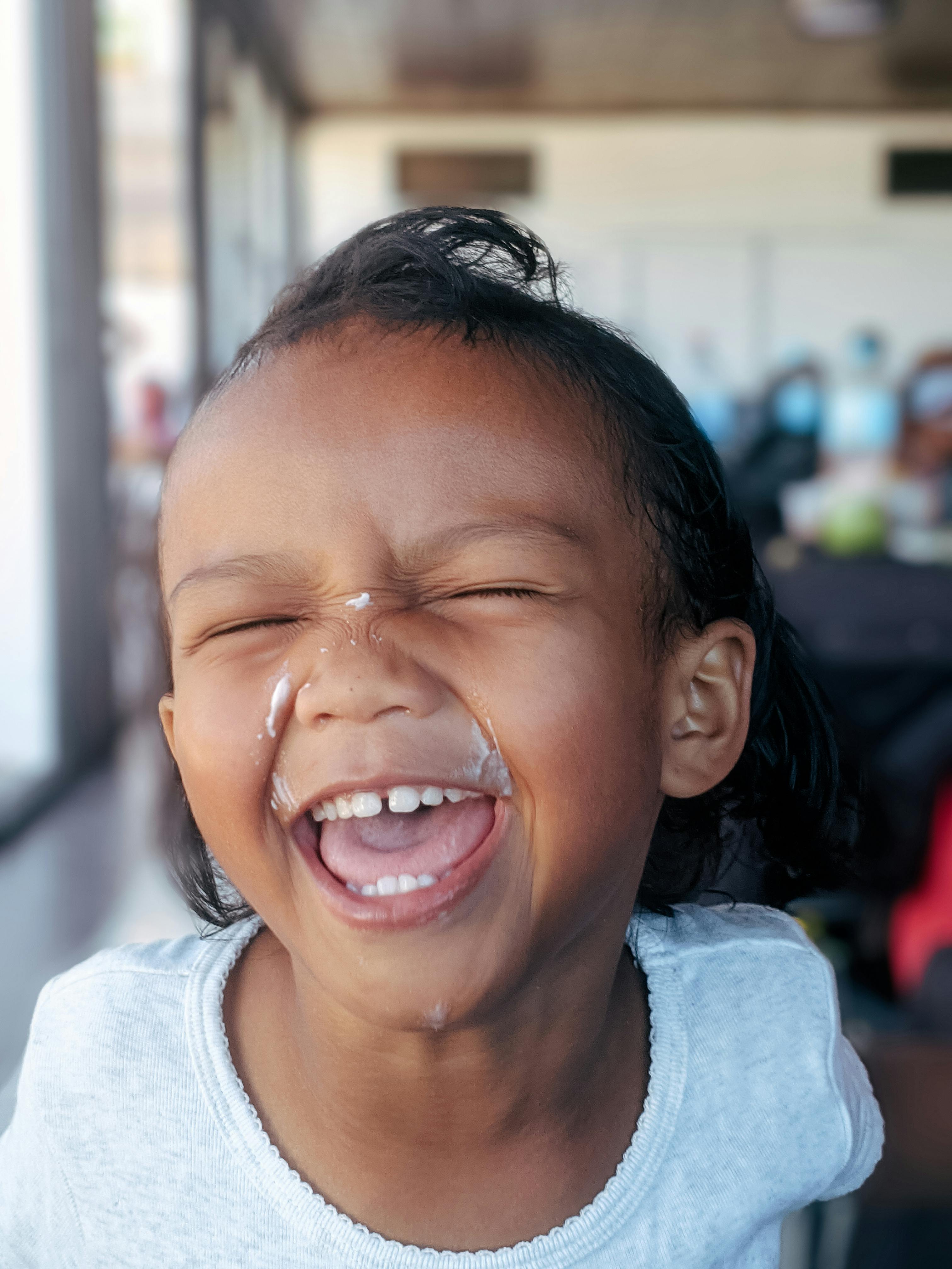 Laughing Young Child With Cream On Face