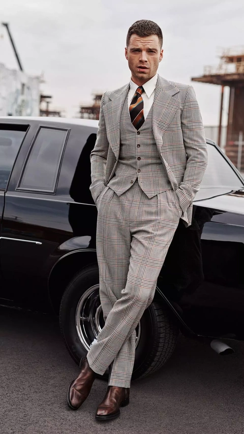 Stylish Man in Plaid Suit Leaning on Car