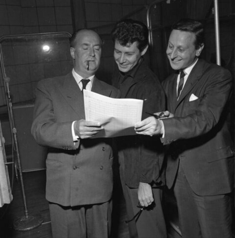 Three Men Reviewing Sheet Music