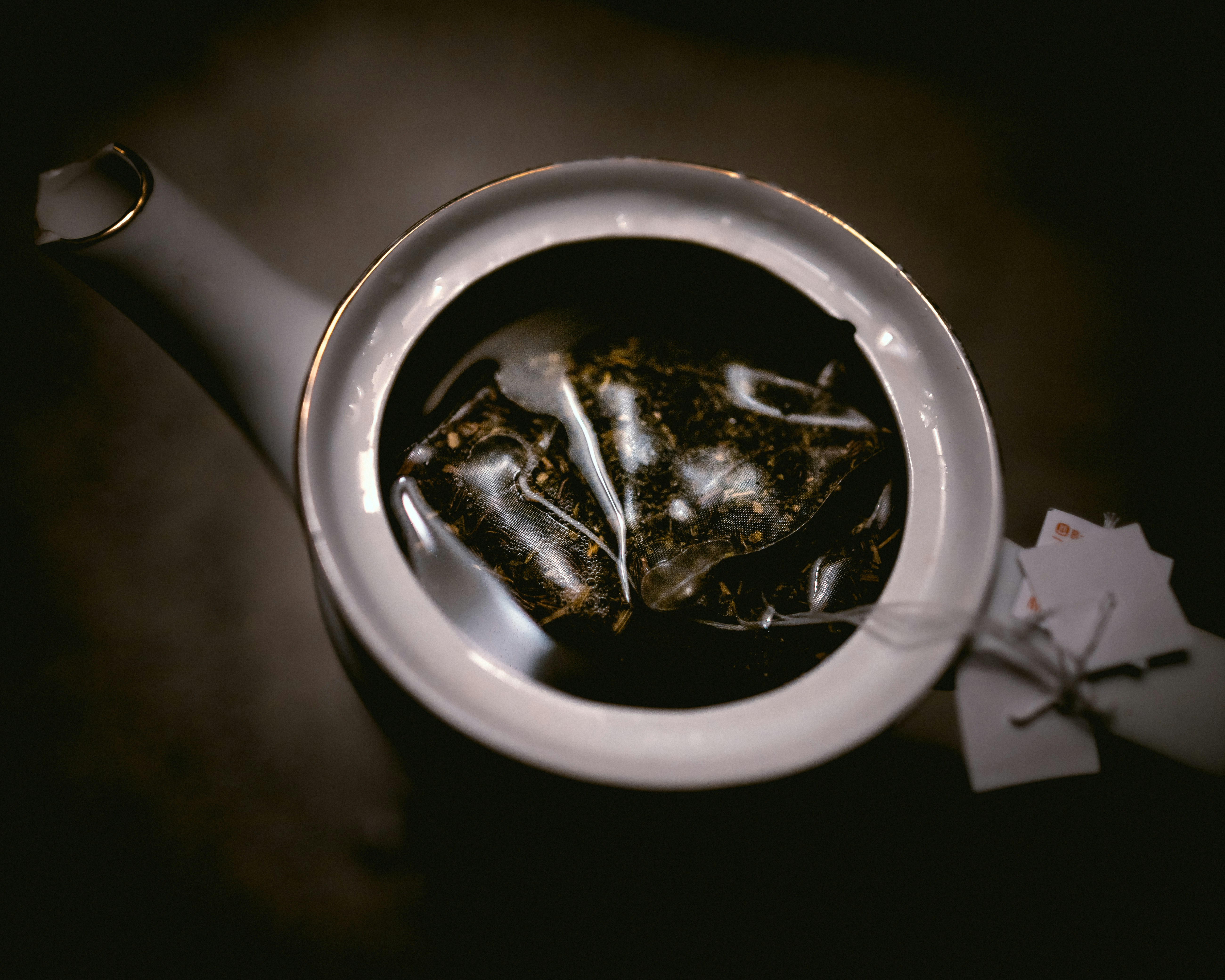 Teabags Steeping in White Teapot