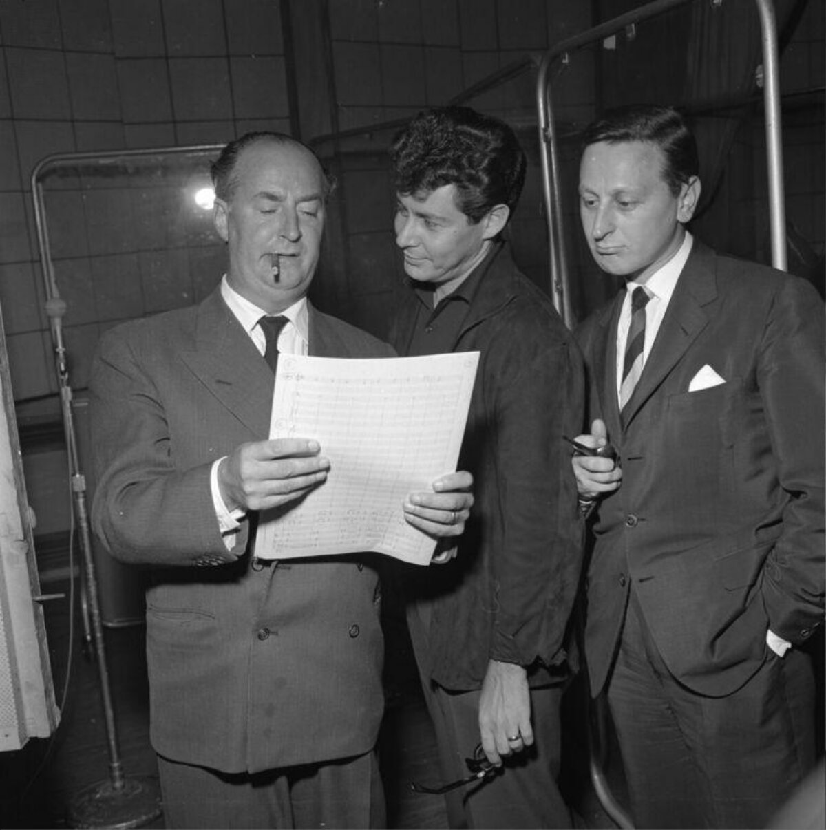 Three Men Reviewing Sheet Music