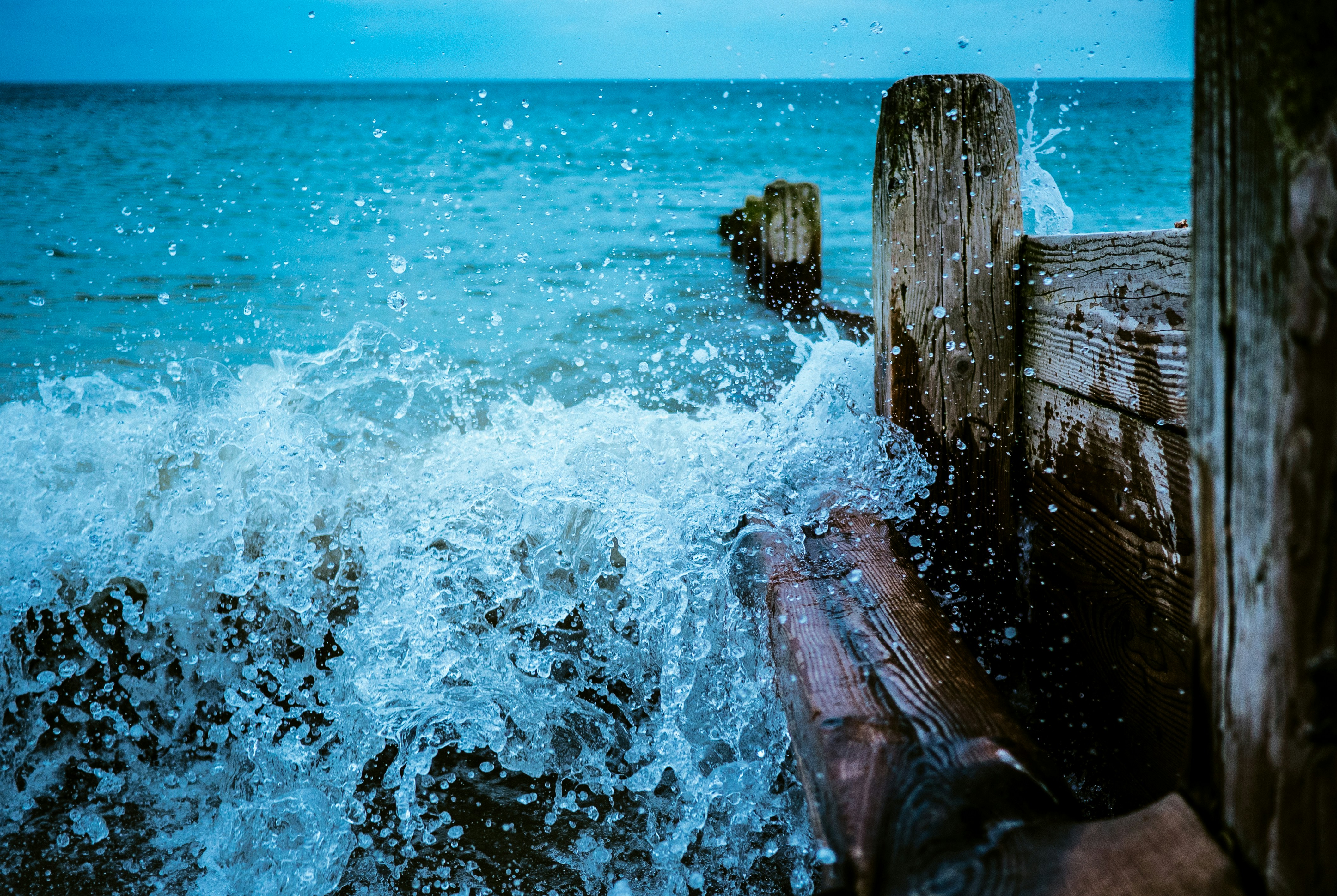 Wave Crashing on Coastal Wooden Groynes
