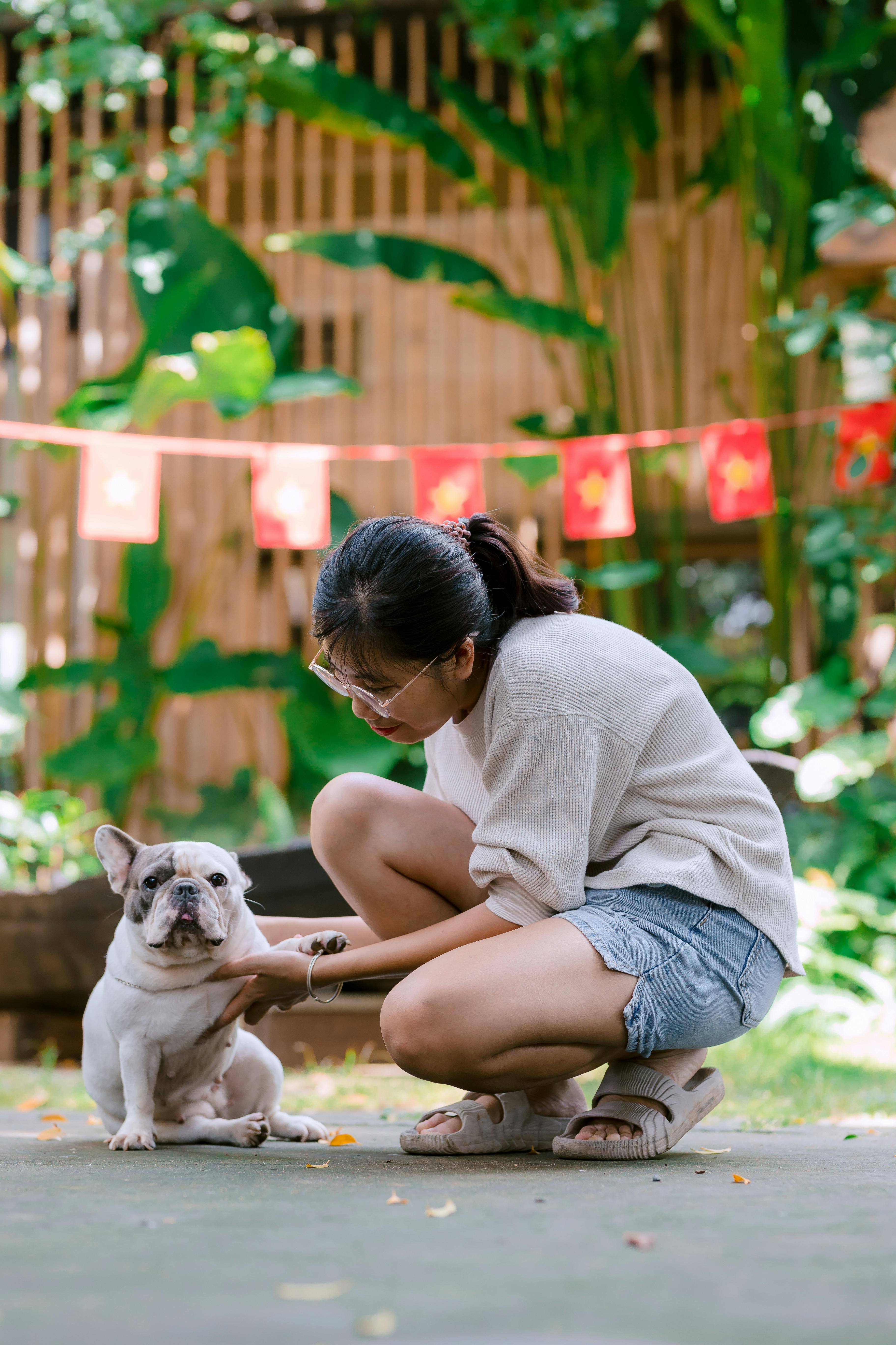 Woman Crouching With Pet French Bulldog